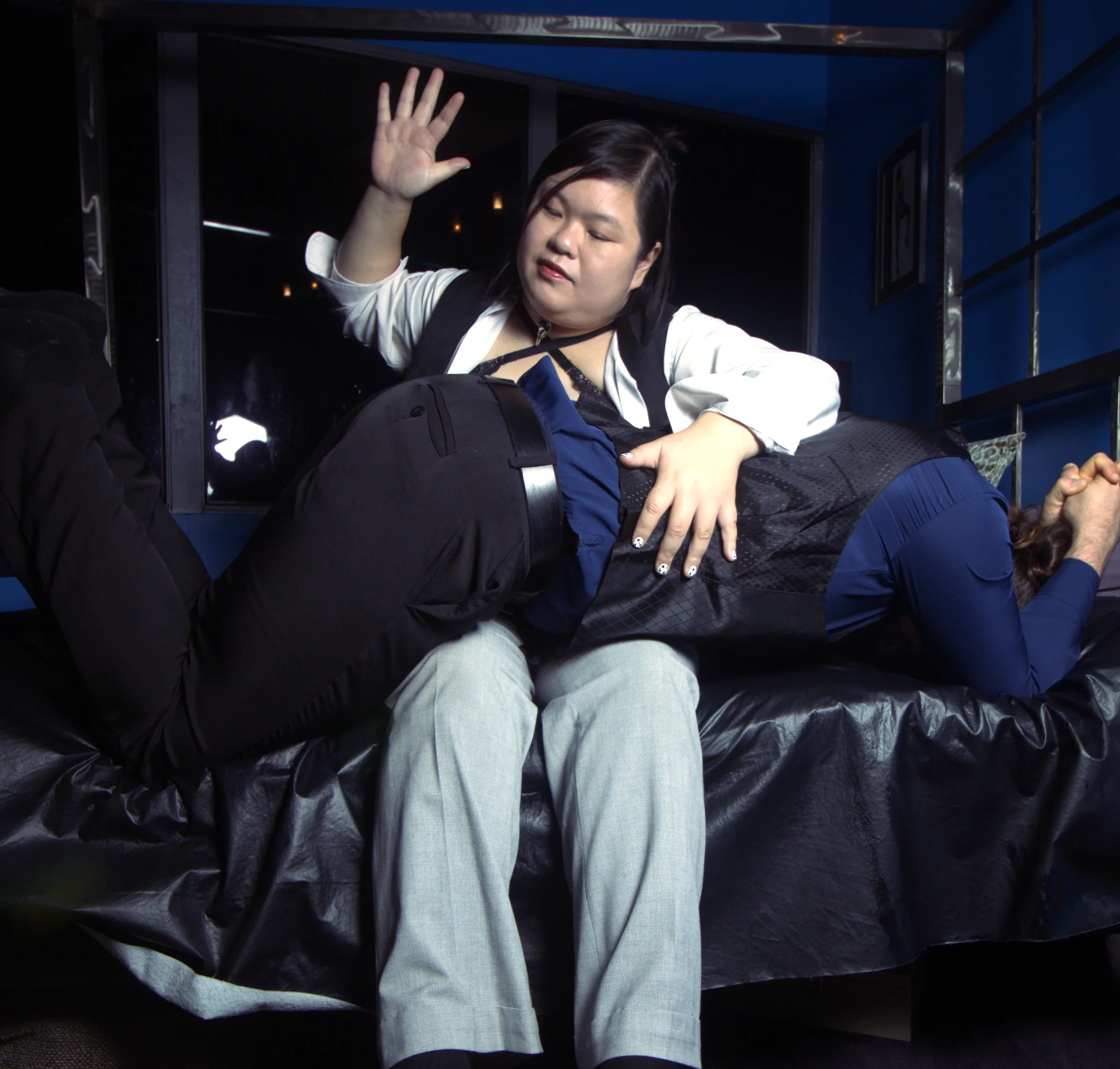 Goddess Shi (Goddess Shiney), has her male submissive over her knee. She is getting ready to spank him.