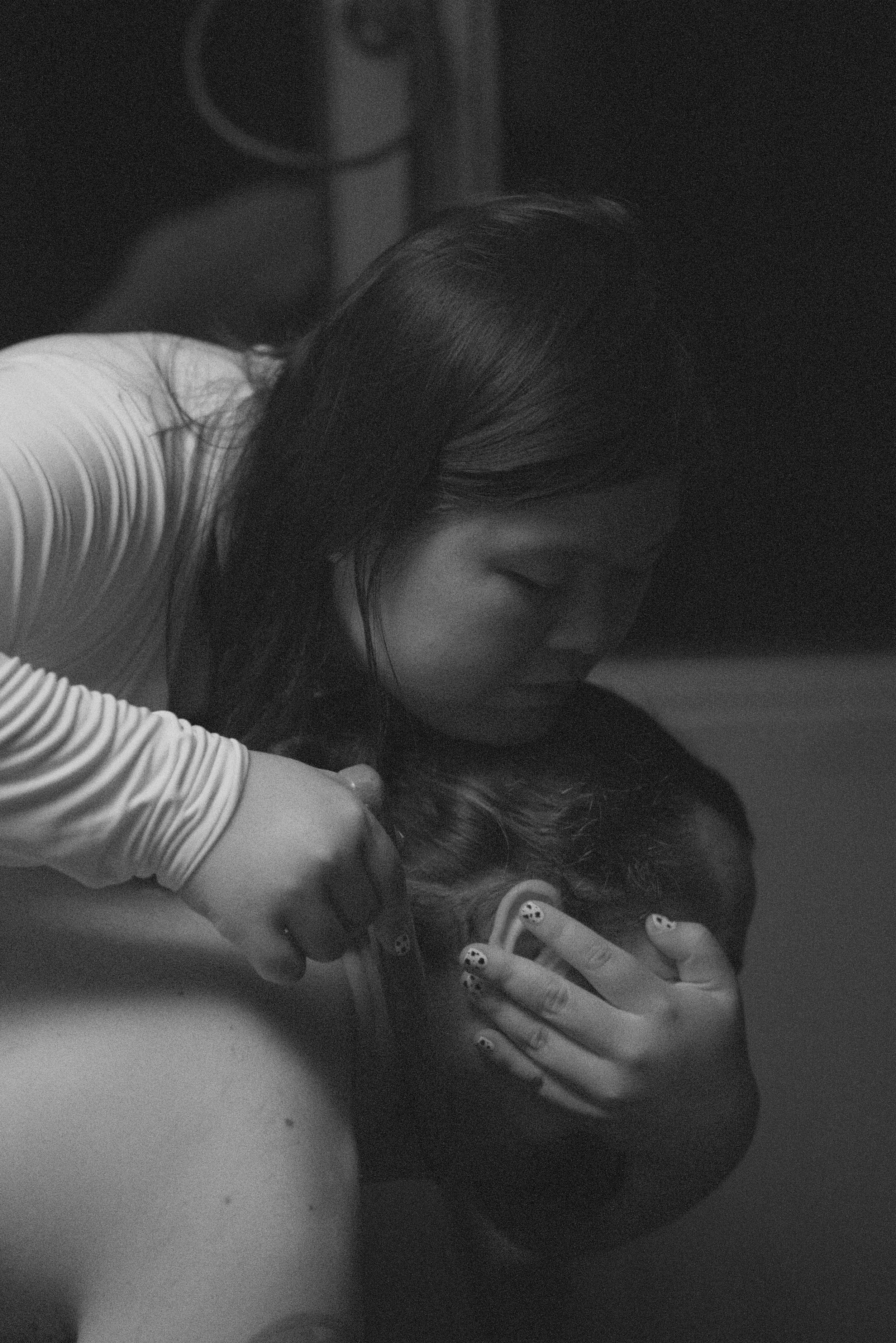 Goddess Shi holds her submissive's head, drawing a wooden knife near his neck while covering his eyes.