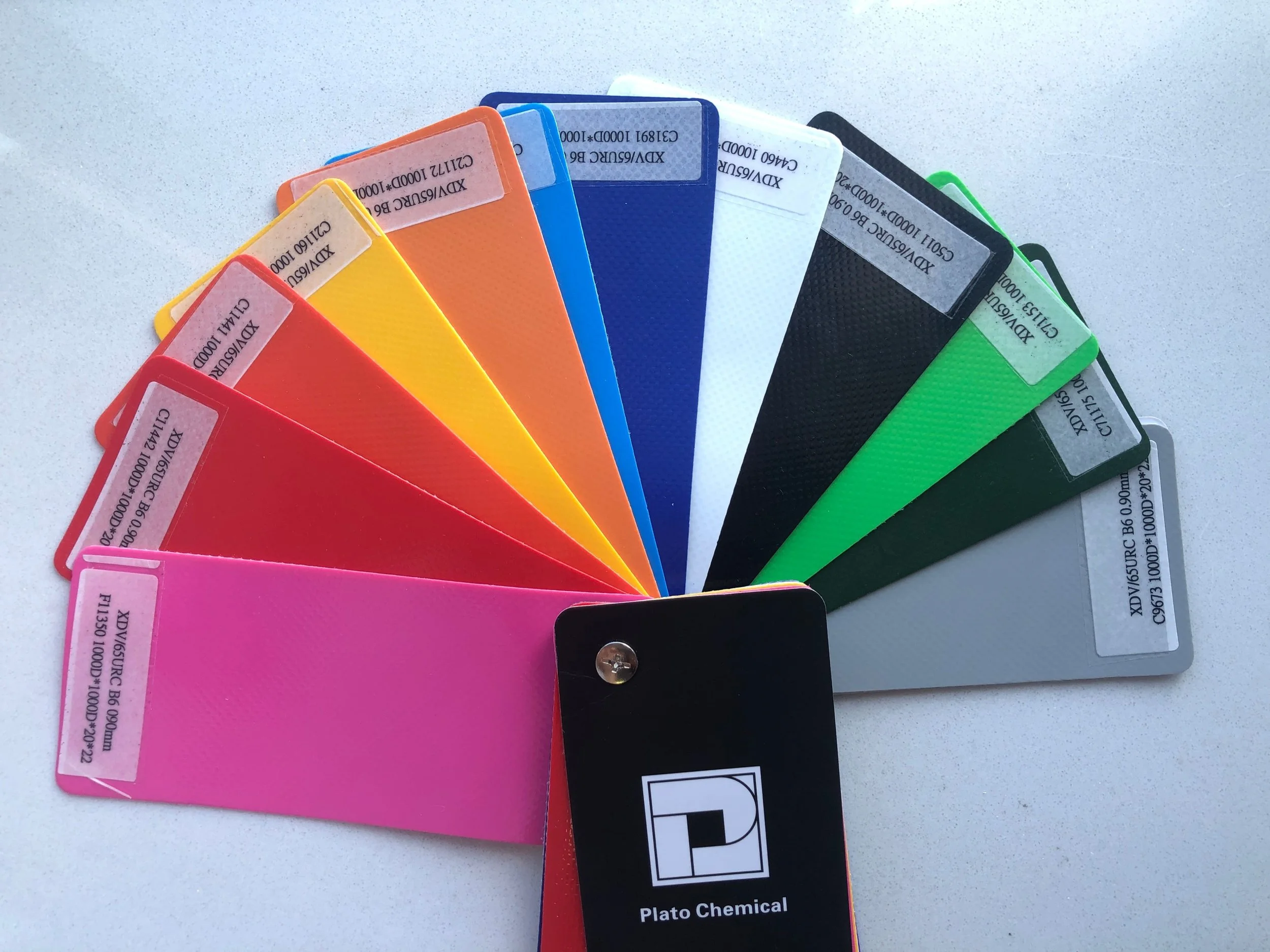 A color palette fan with various colors including pink, red, yellow, orange, blue, white, black, green, and gray, labeled with chemical information from Plato Chemical.