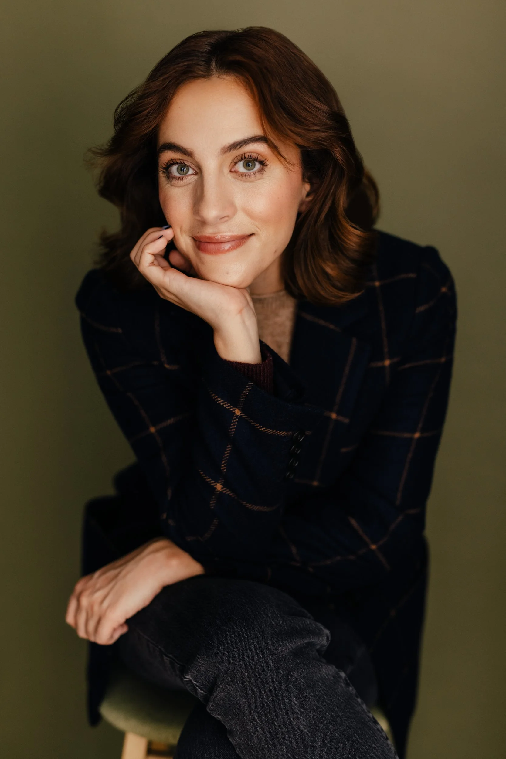 a young woman in a blazer smiling at the camera
