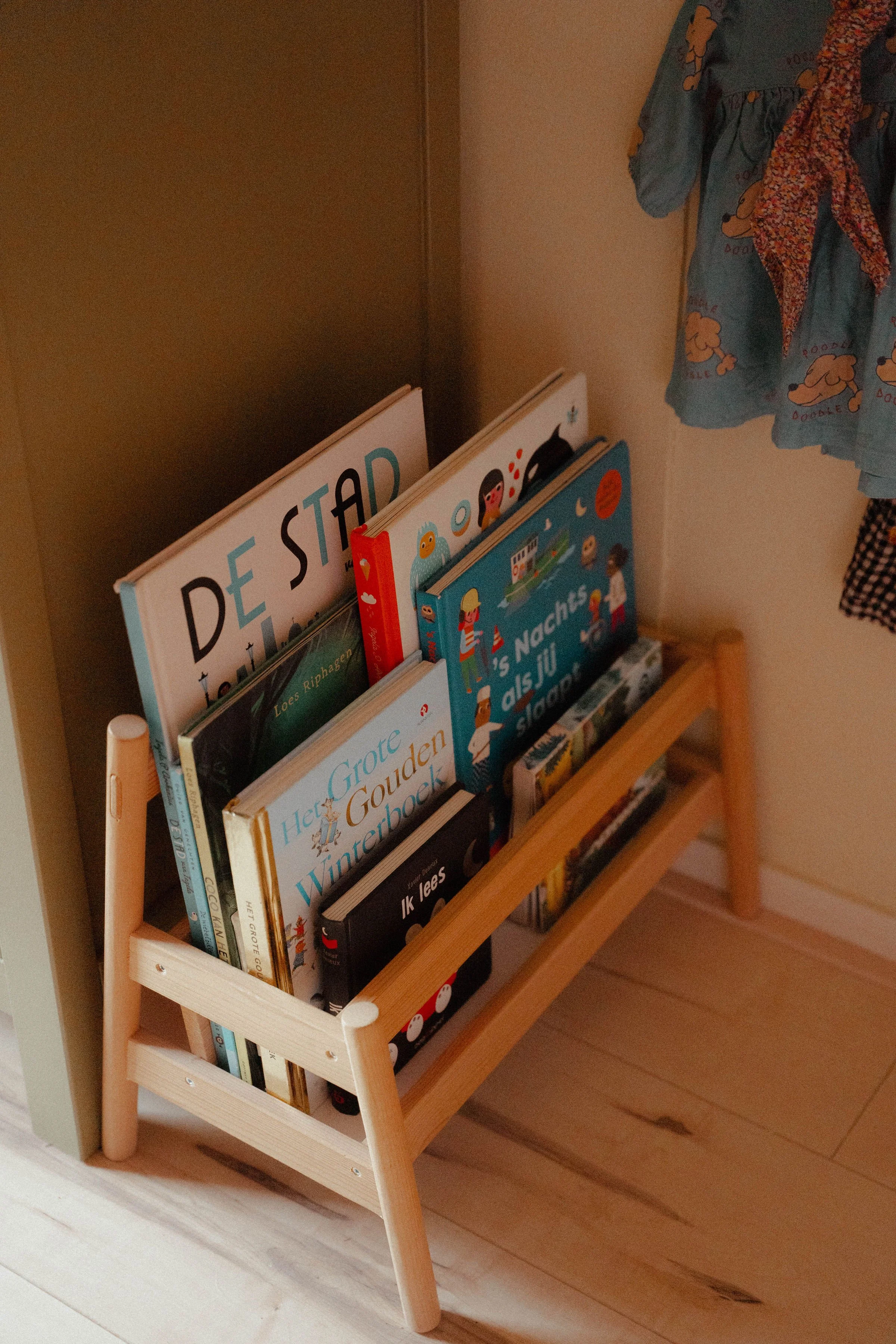 Detail van een kleurrijke  meisjeskamer houten boekenrekje