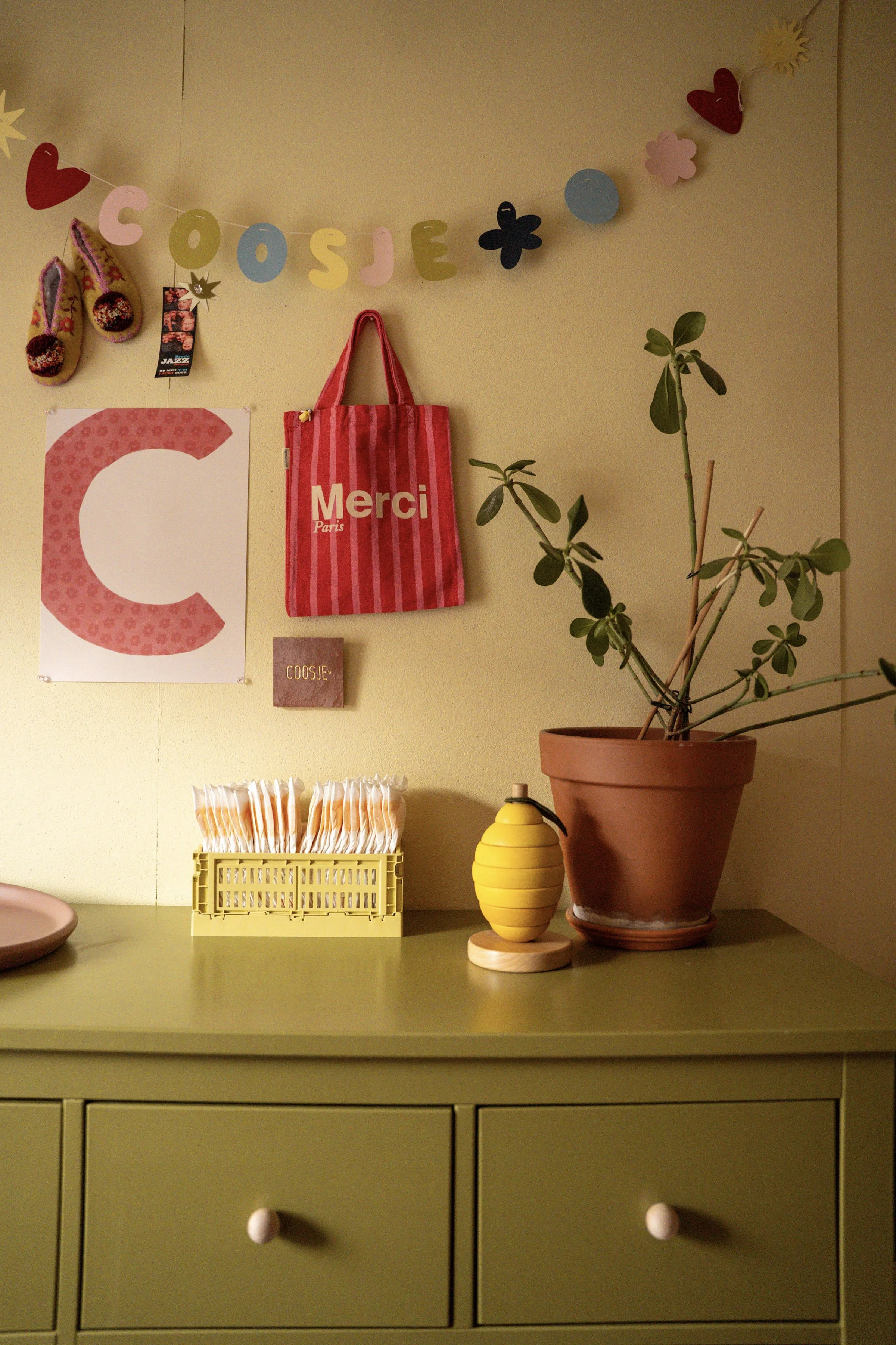 Kinderkamer inspiratie met groene commode, persoonlijke accessoires en een warm kleurenpalet.