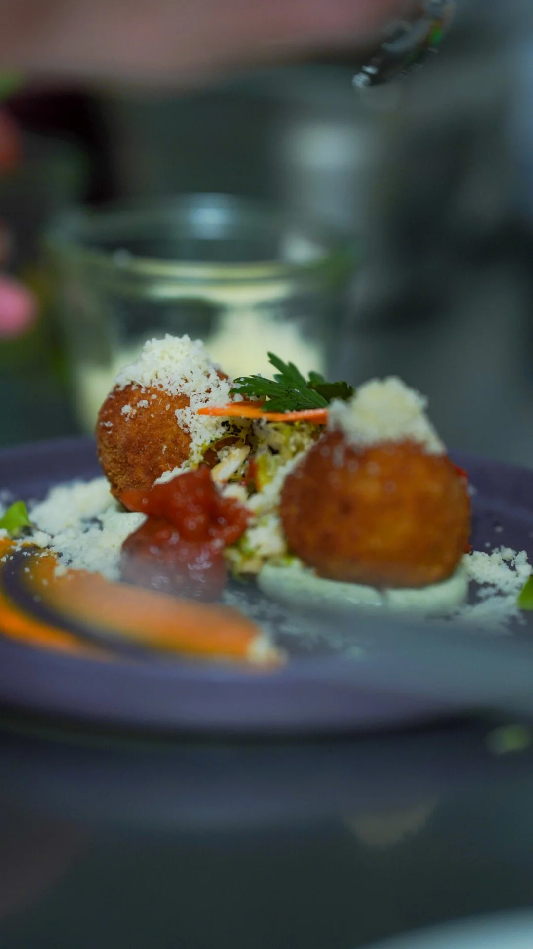 Frittierte Bällchen mit Tomatensauce, garniert mit Petersilie, auf einem Teller