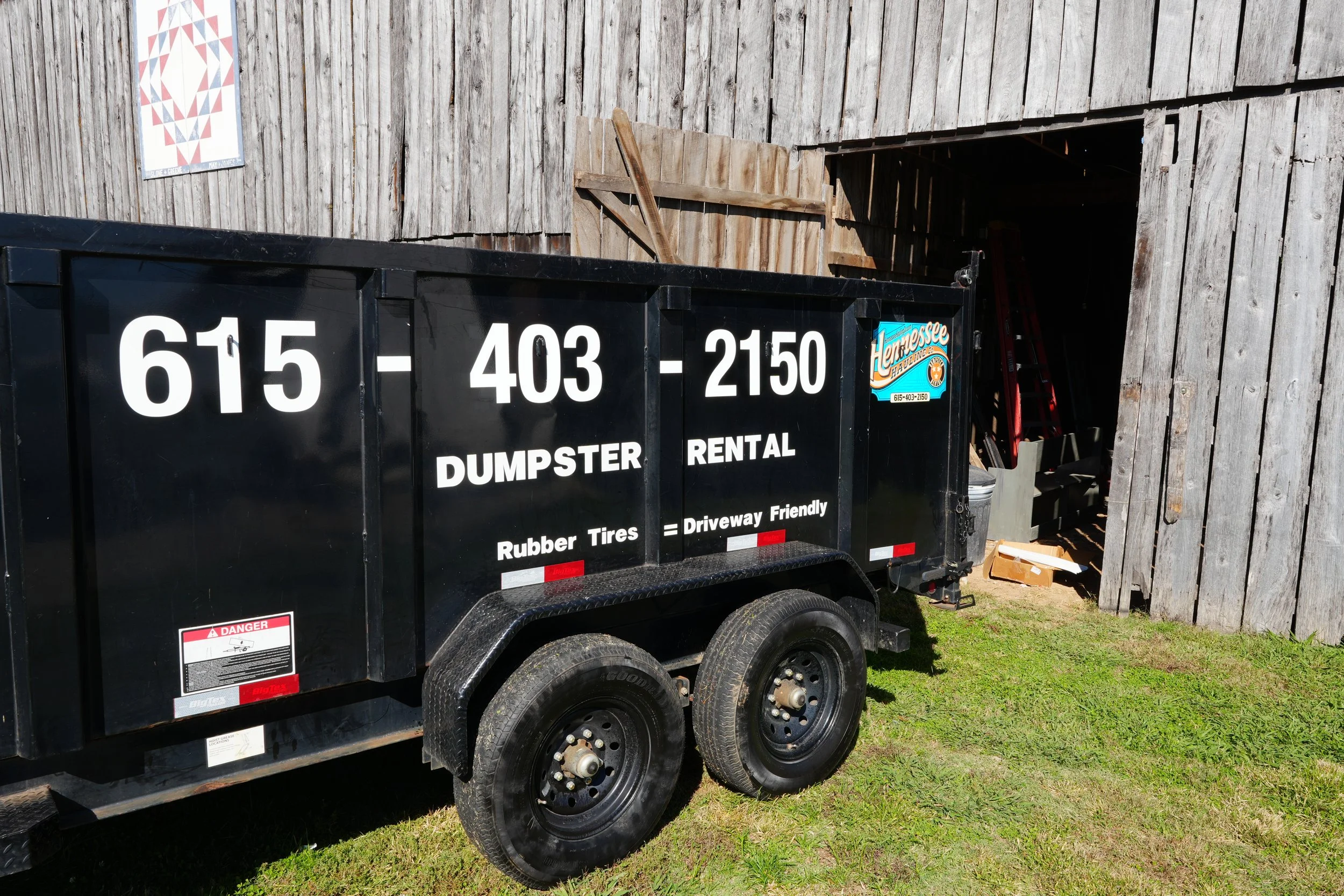 A mountain landscape with snow-capped peaks in the background and a modern building on a grassy hill in the foreground.