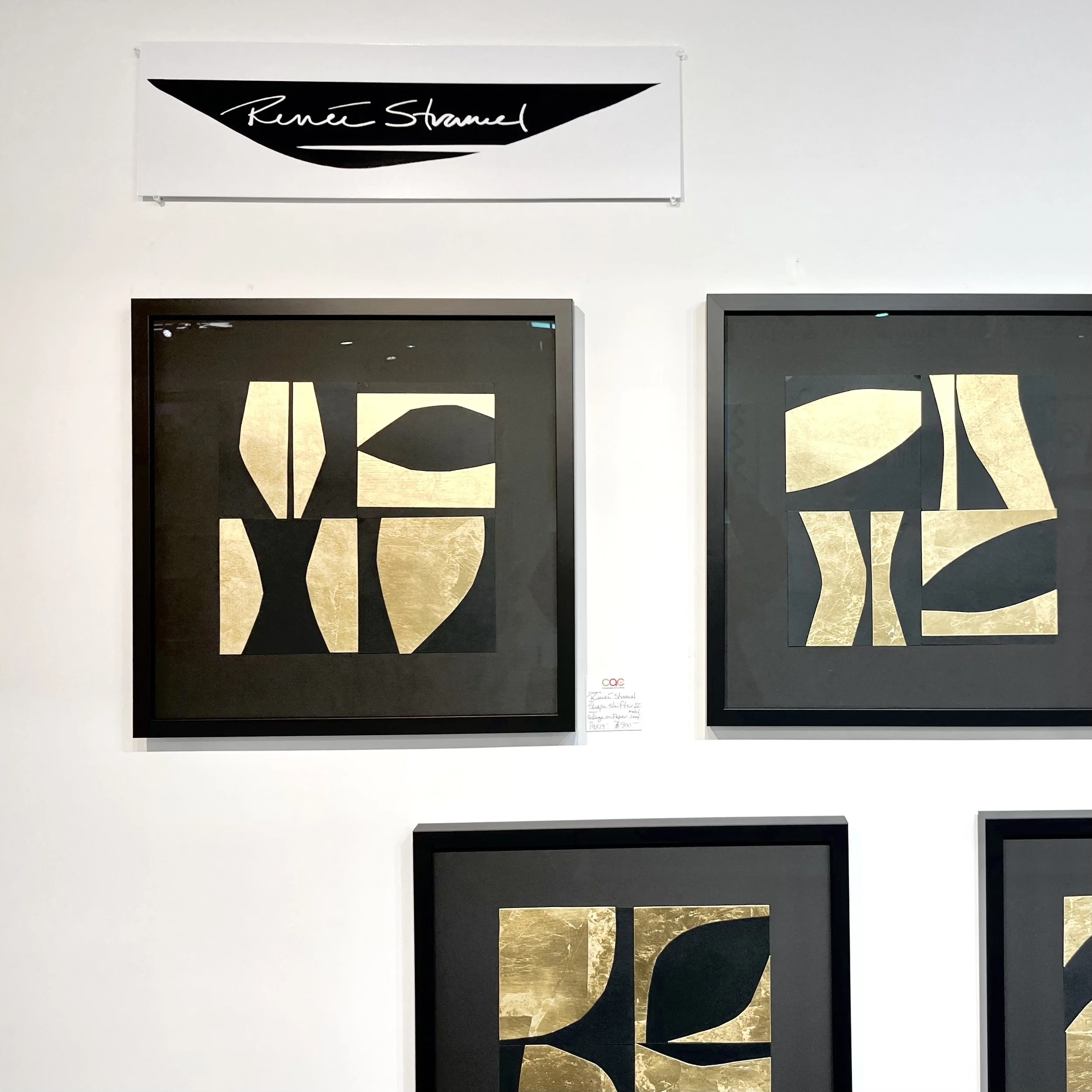 a sign on a wall reads 'renee stramel' in a modern design with three abstract artworks in black and gold underneath. 