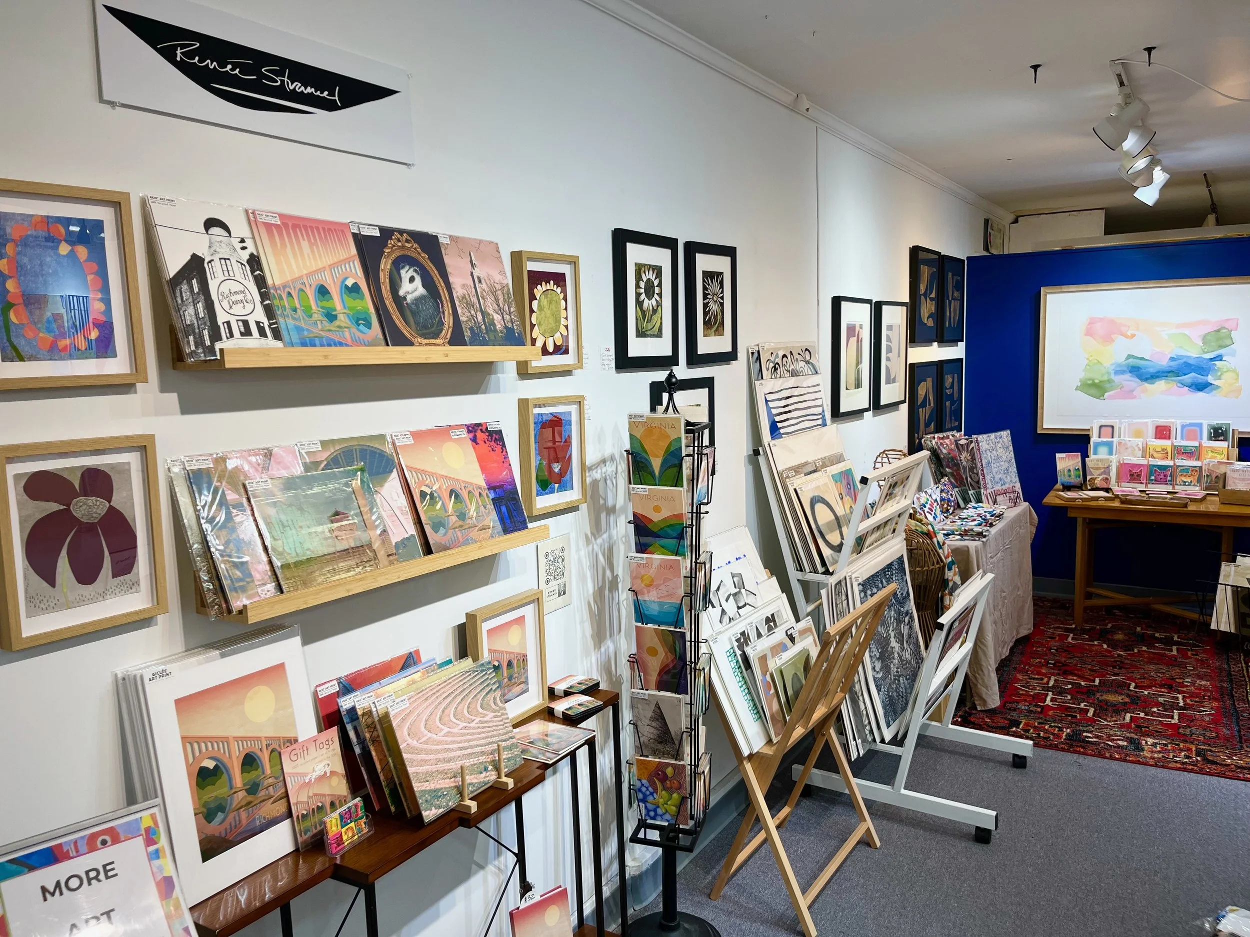 various artwork, prints, stationery and other small gifts align a wall at Crossroads art center featuring work by Renee Stramel.