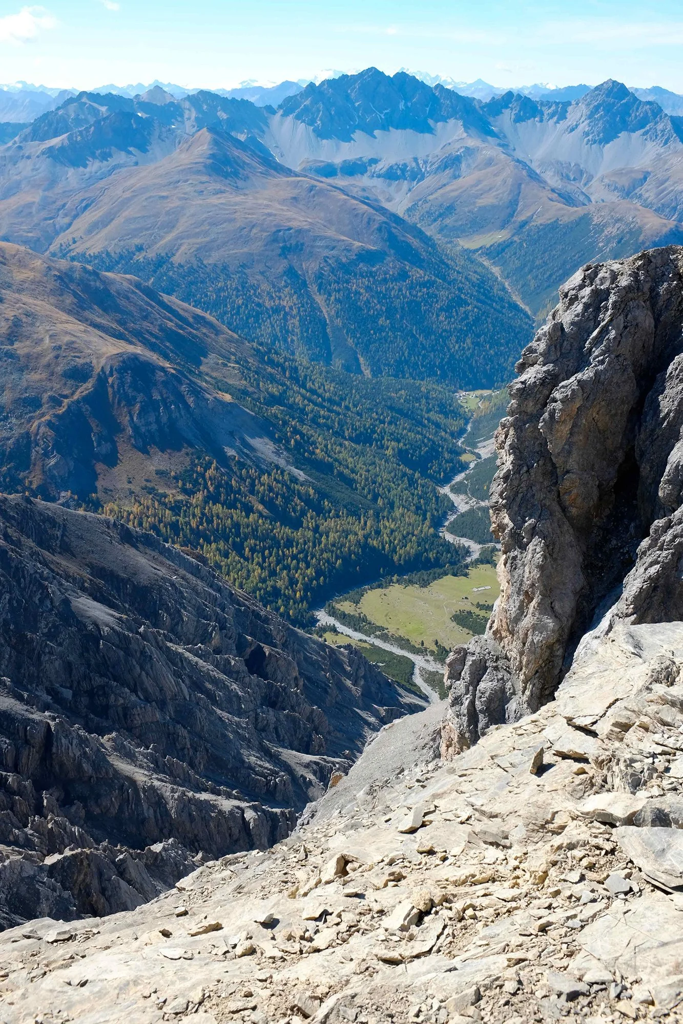 Berglandschaft mit hohen Gipfeln, grünen Tälern und Flüssen, Blick von einer Felsklippe im Gebirge.