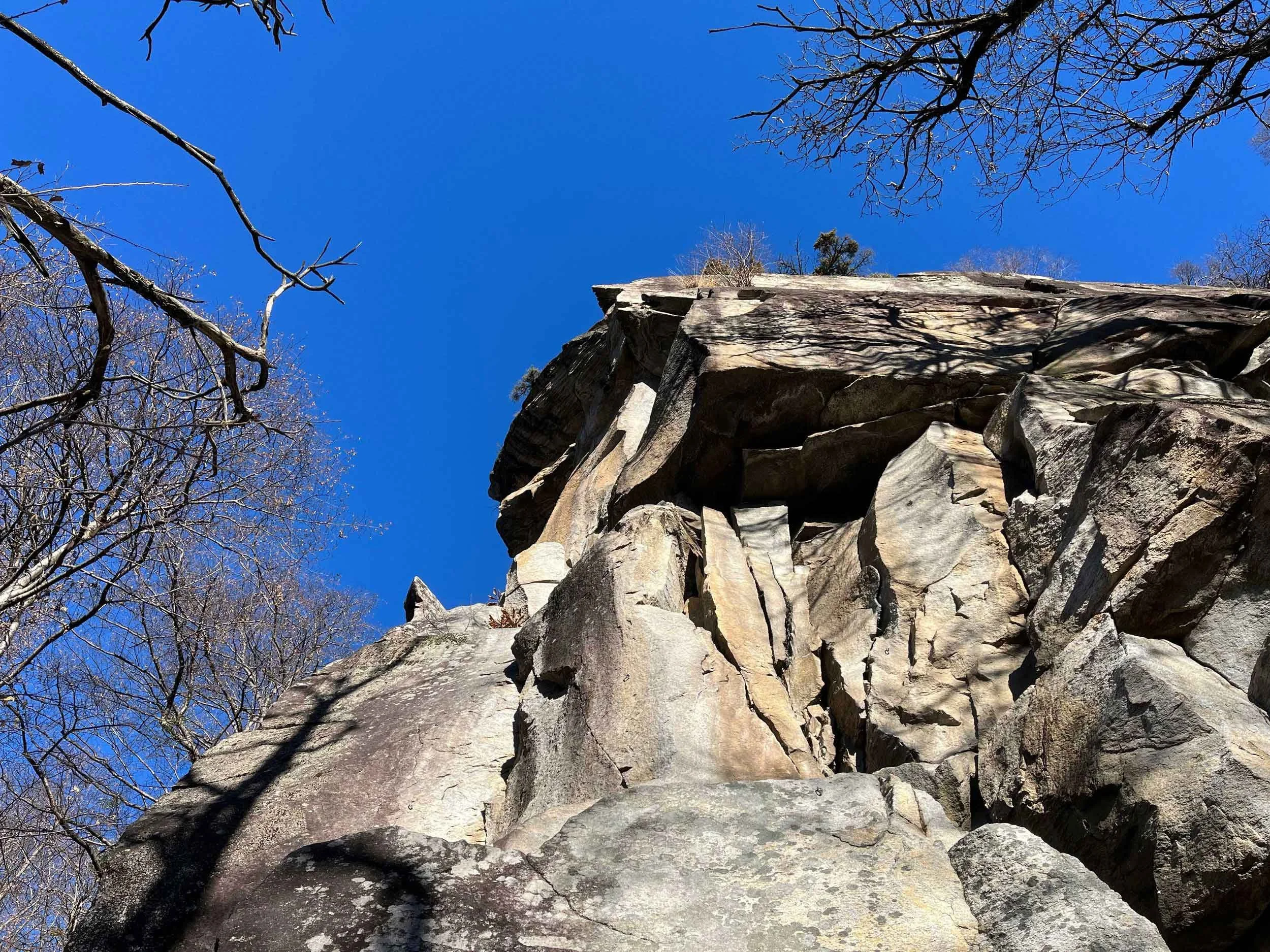 Berg mit Felsen und Bäumen unter klarem blauen Himmel