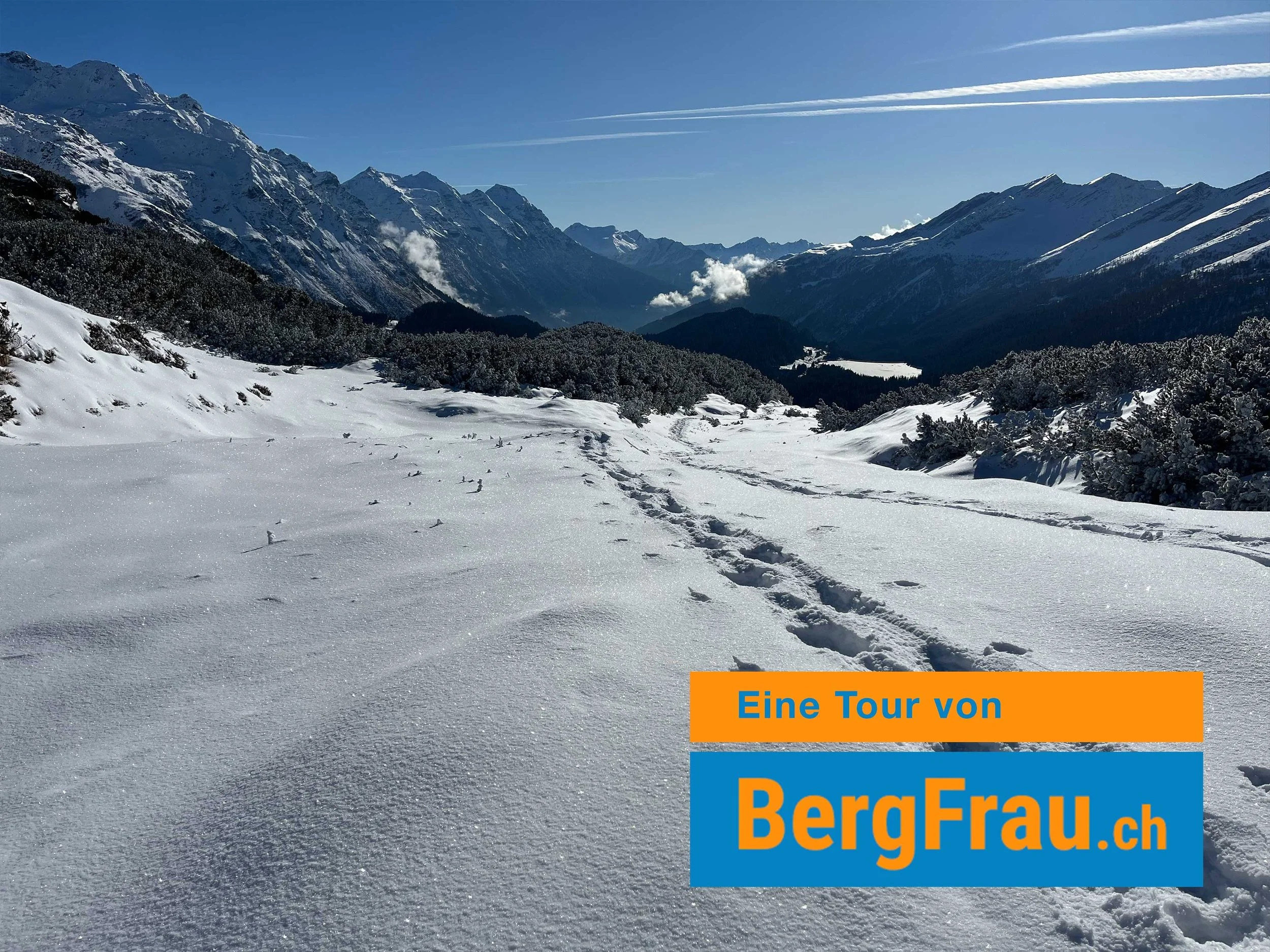 Schneebedeckte Berge und ein Himmel mit einigen Wolken. Es sieht aus wie eine Winterlandschaft in den Alpen.