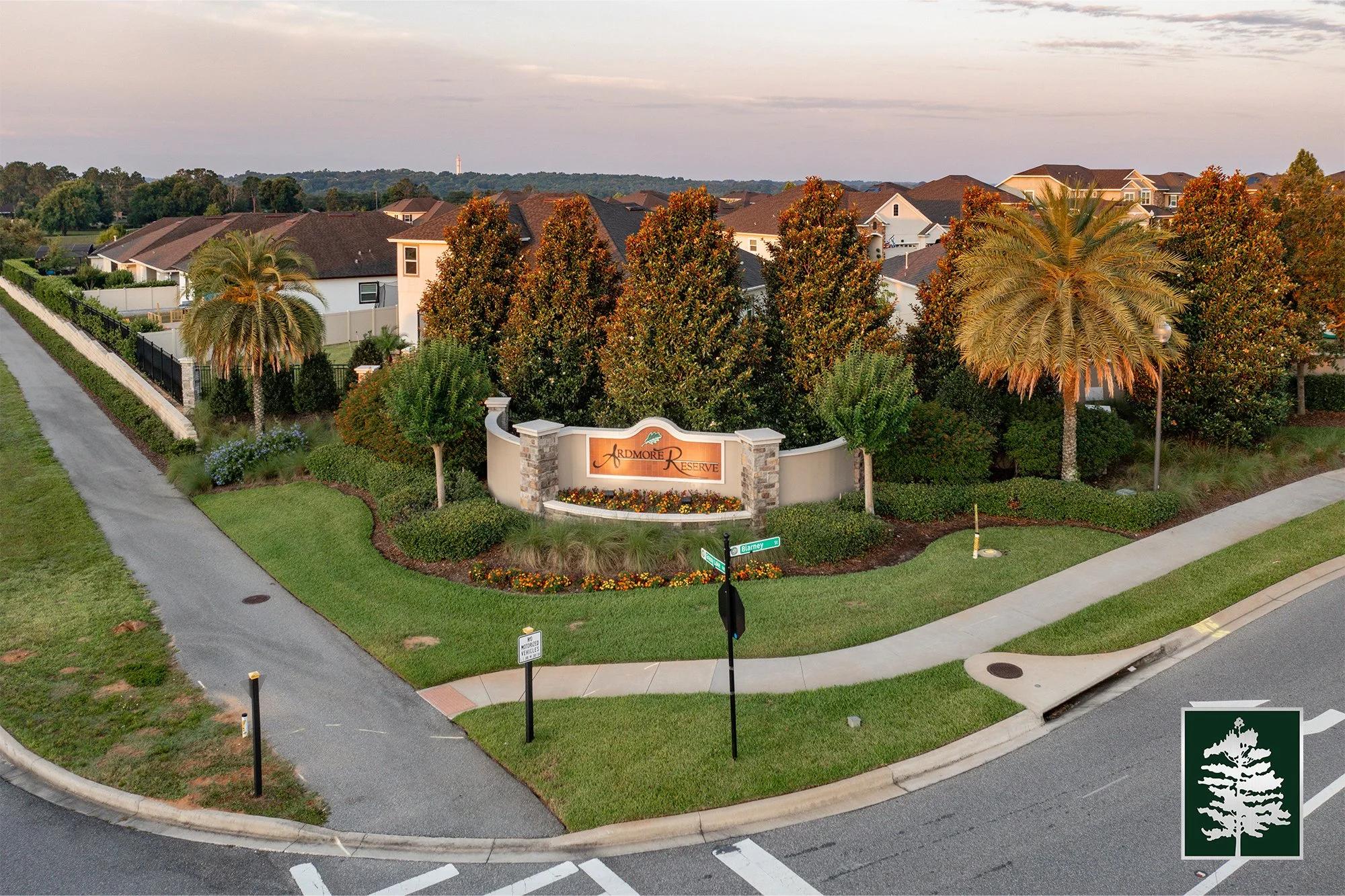 Entrance sign for Ardmore Reserve neighborhood, surrounded by landscaped bushes and trees, with residential homes and streets in the background.