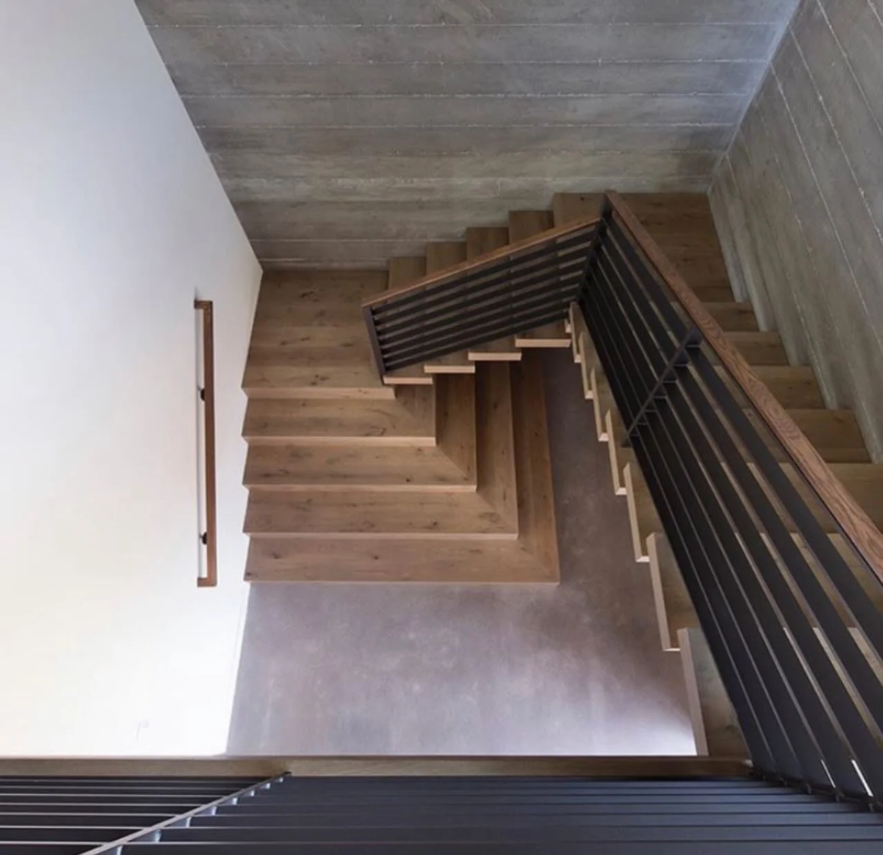 The power of natural materials done right. 

Warm wood tones against concrete textures creates a look that feels modern, grounded, and timeless all at once. These custom stairs might just be the favorite detail in the entire home.

Builder @schmitt_c