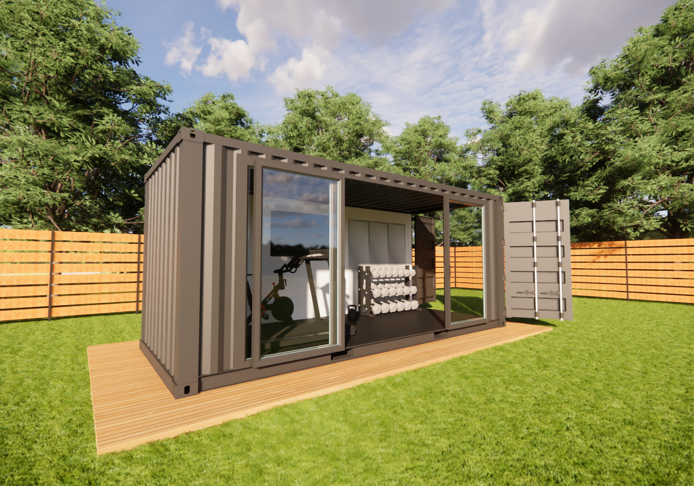 A modern backyard gym made from a repurposed shipping container with sliding glass doors, containing workout equipment including dumbbells and an exercise bike, set on a wooden platform within a green yard and wooden fence surrounded by trees.