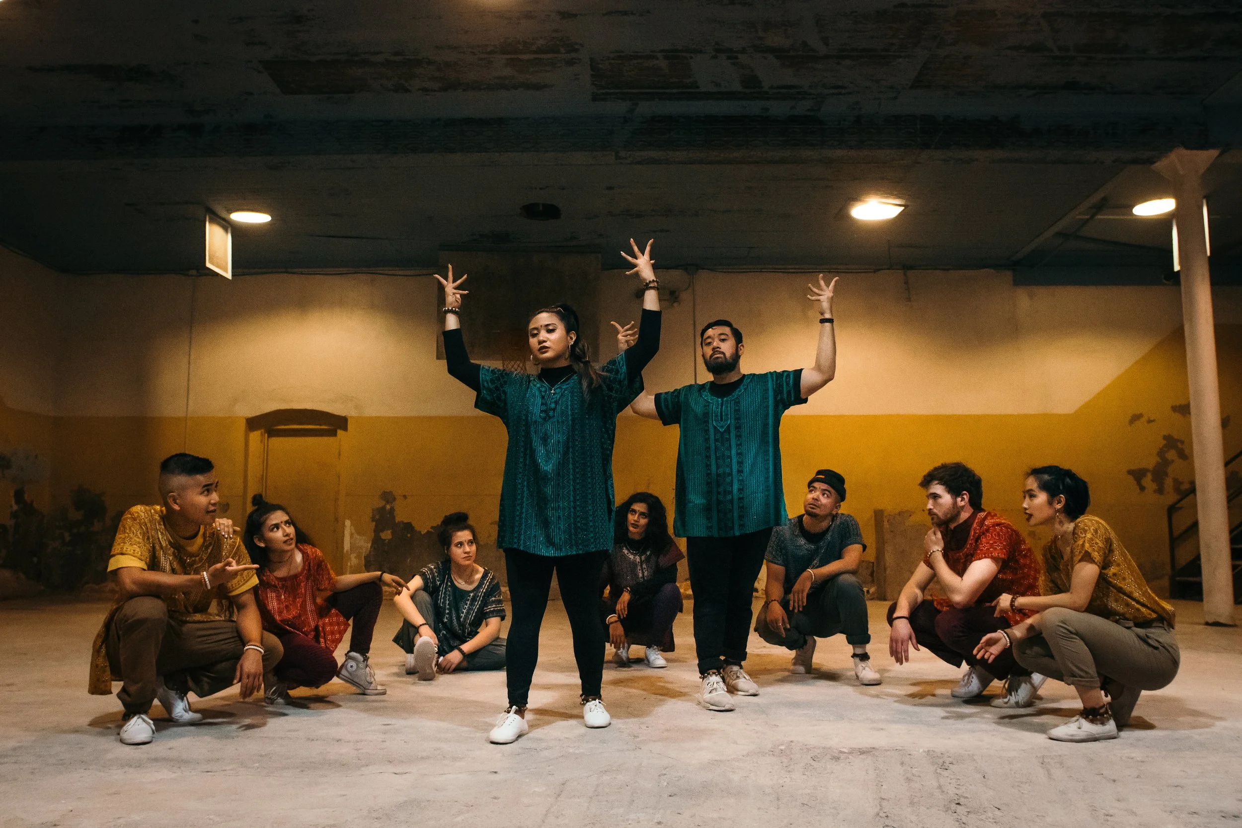Group of dancers performing in the worn, yellow-painted gym space of Gymnopedie in Bushwick