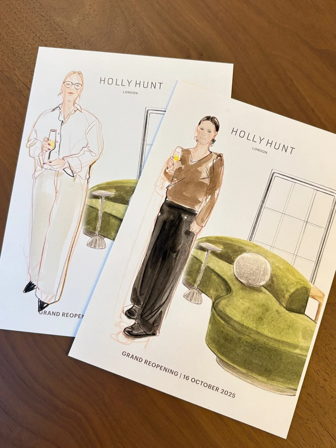 Two illustrated flyers for HOLLY HUNT, featuring women holding glasses, one with glasses and pink hair wearing a white blouse and pants, and the other with dark hair in a brown top and black pants, with a green sectional sofa and window in the background. Text on the flyers reads "GRAND REOPENING | 16 OCTOBER 2025."