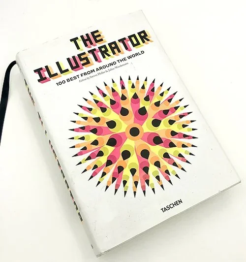 A book titled 'The Illustrator: 100 Best from Around the World' published by Taschen, featuring a colorful, spiky, circular design on the cover.