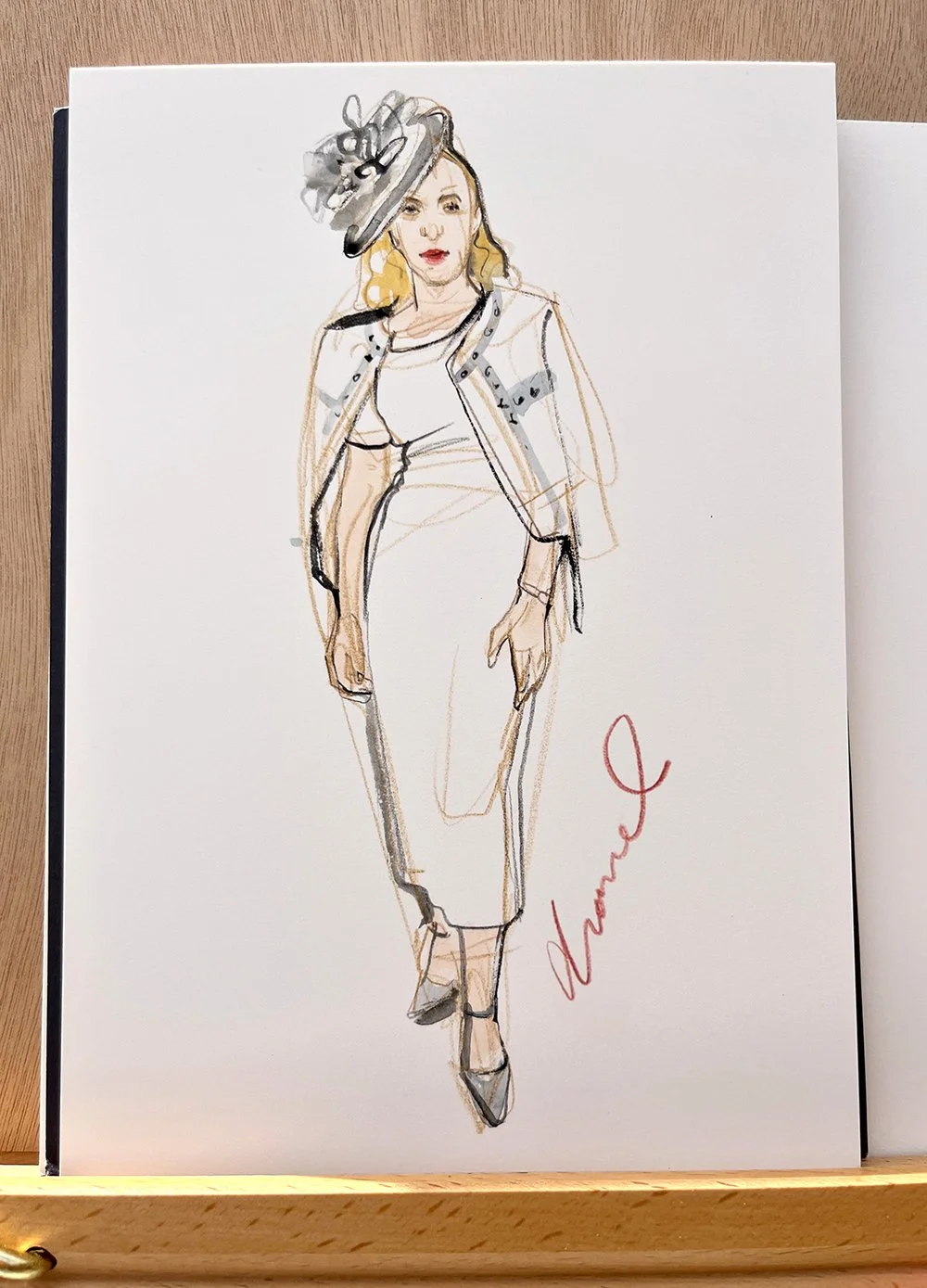 Fashion illustration of a woman wearing a hat, blazer, and pencil skirt, signed with the name 'Vance'.