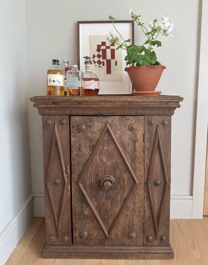 Image of a vintage wooden cabinet accessories with a plant pot and a painting