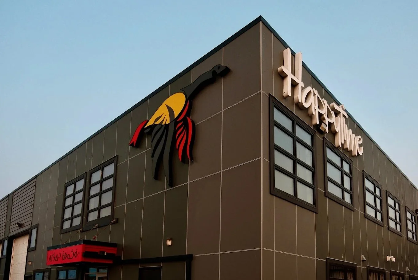 Building with a sign that says 'Happtime' and an logo of a hummingbird on the corner.