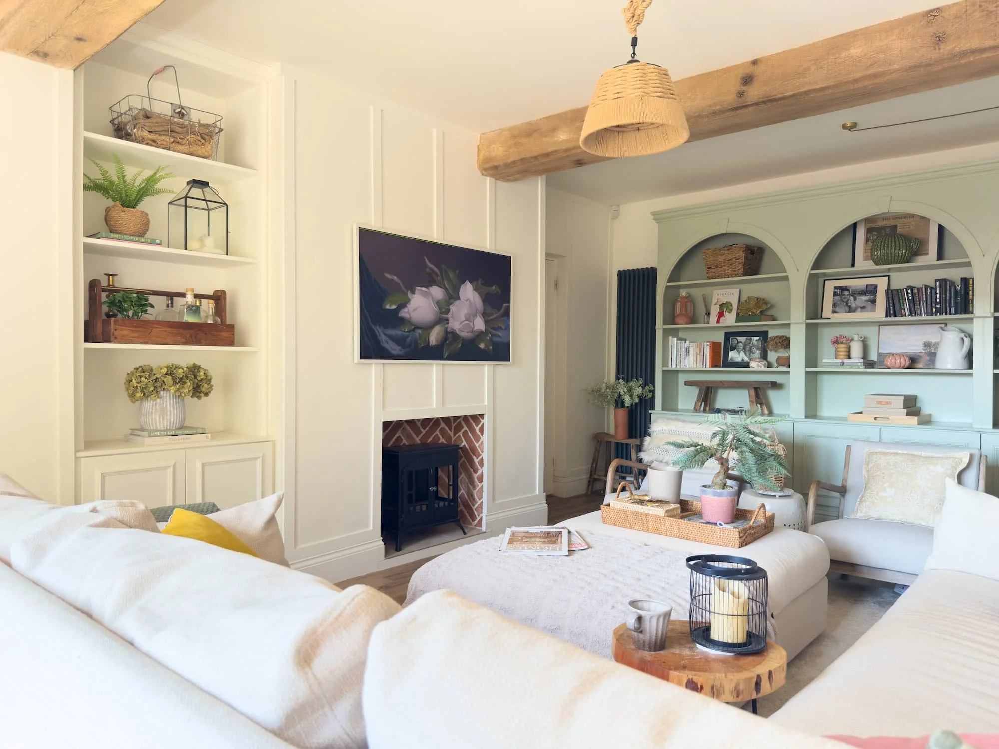 Classic living room with exposed beam, panelled walls and sage green alcove shelving in a Derbyshire home