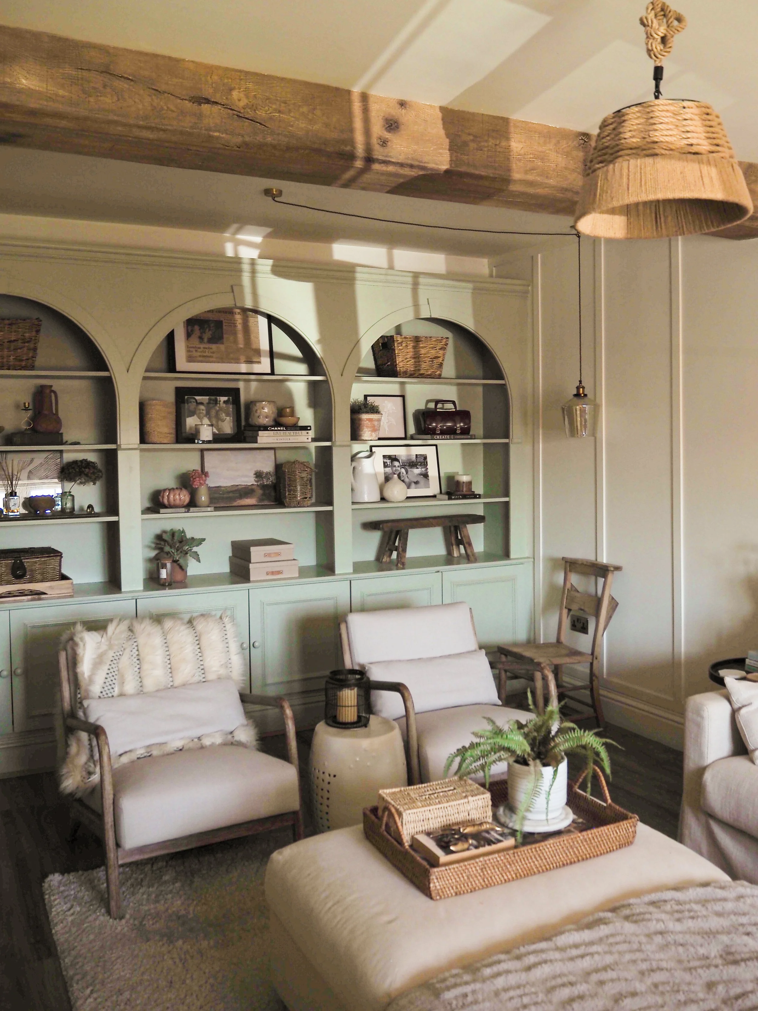 Cosy sitting room with sage green alcove shelving and cream armchairs, Derbyshire interior design