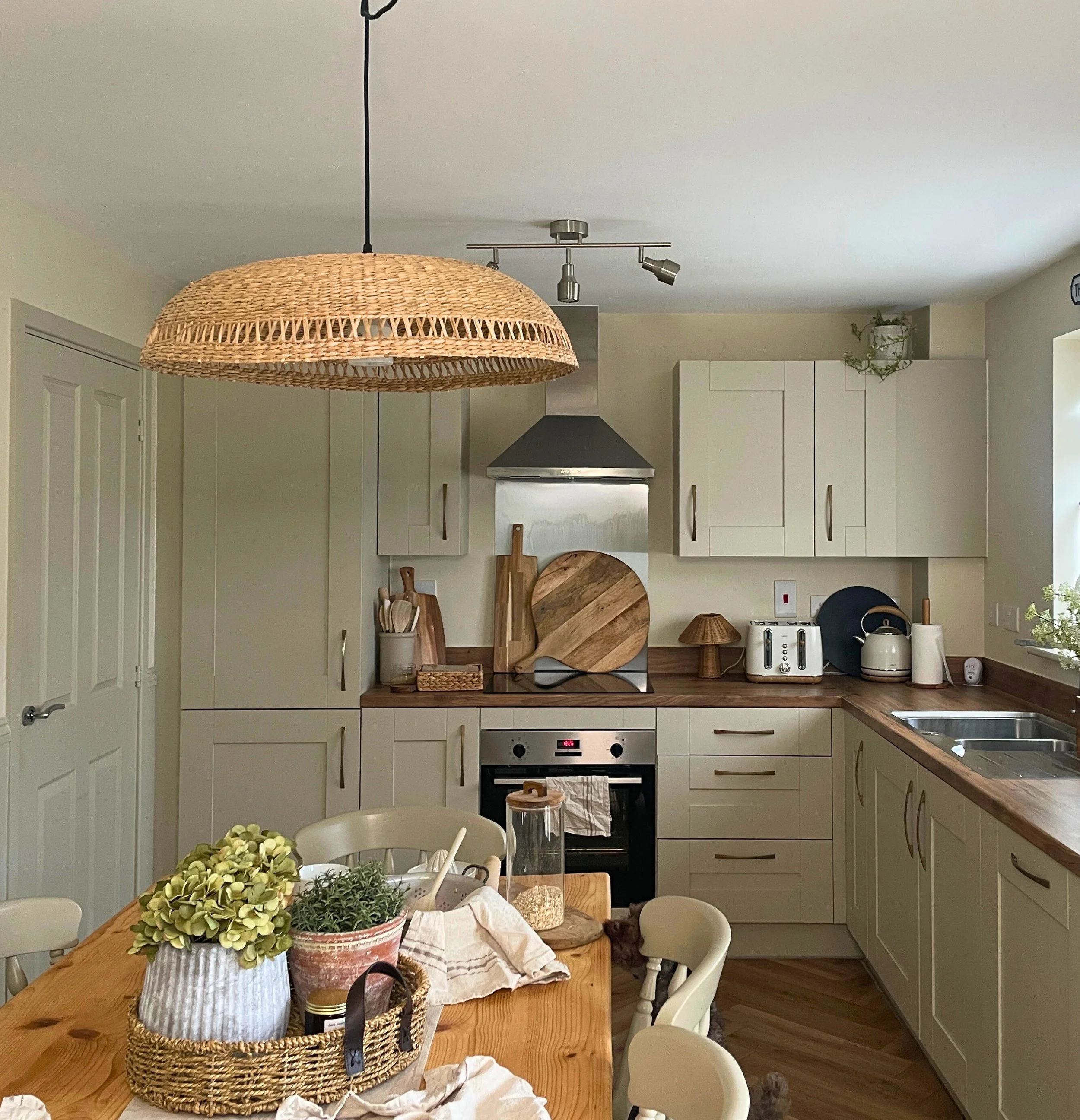 Cream shaker kitchen with wood worktops and a rattan pendant light