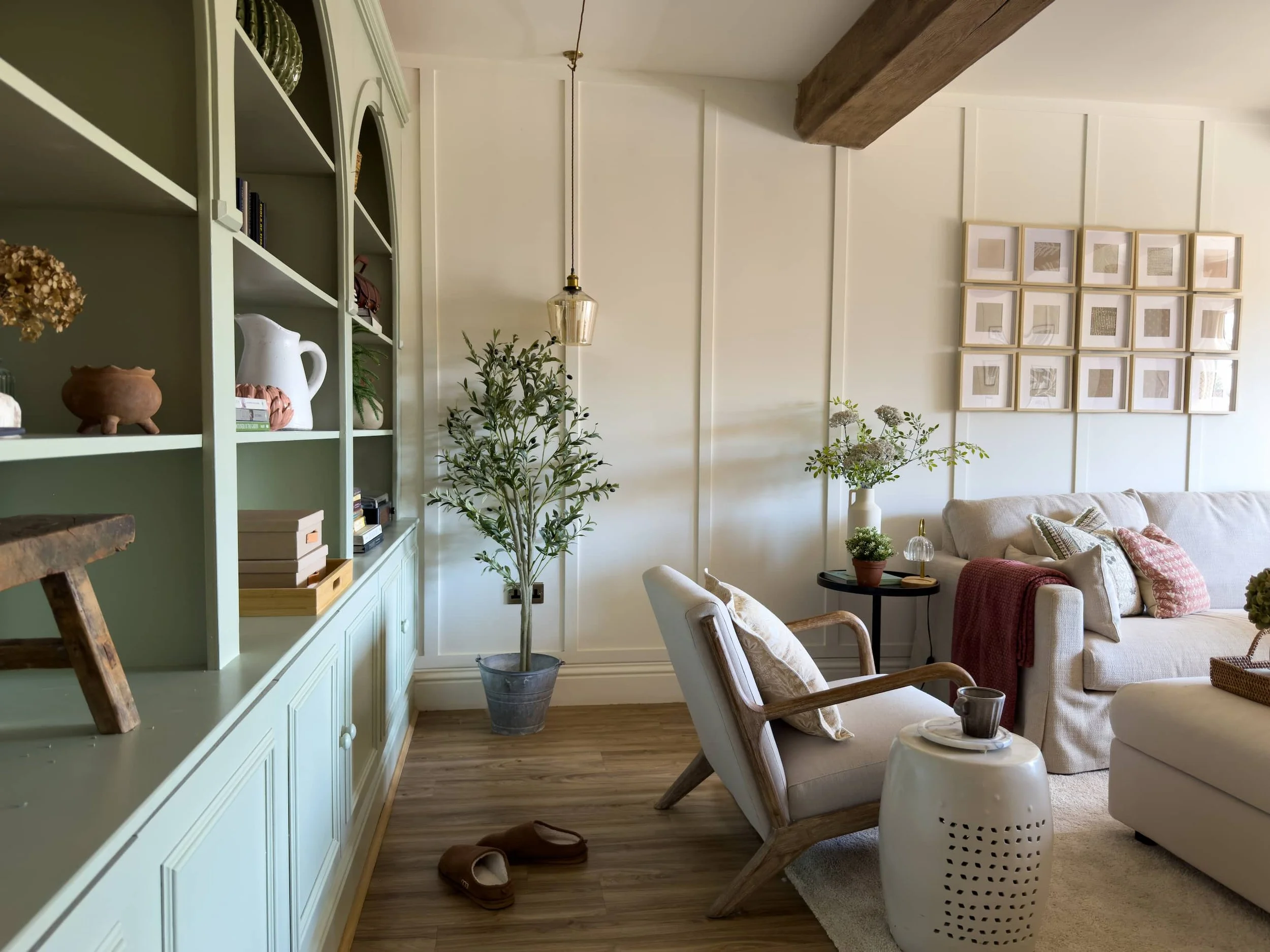 Panelled open plan living space with exposed beam and built-in cabinetry