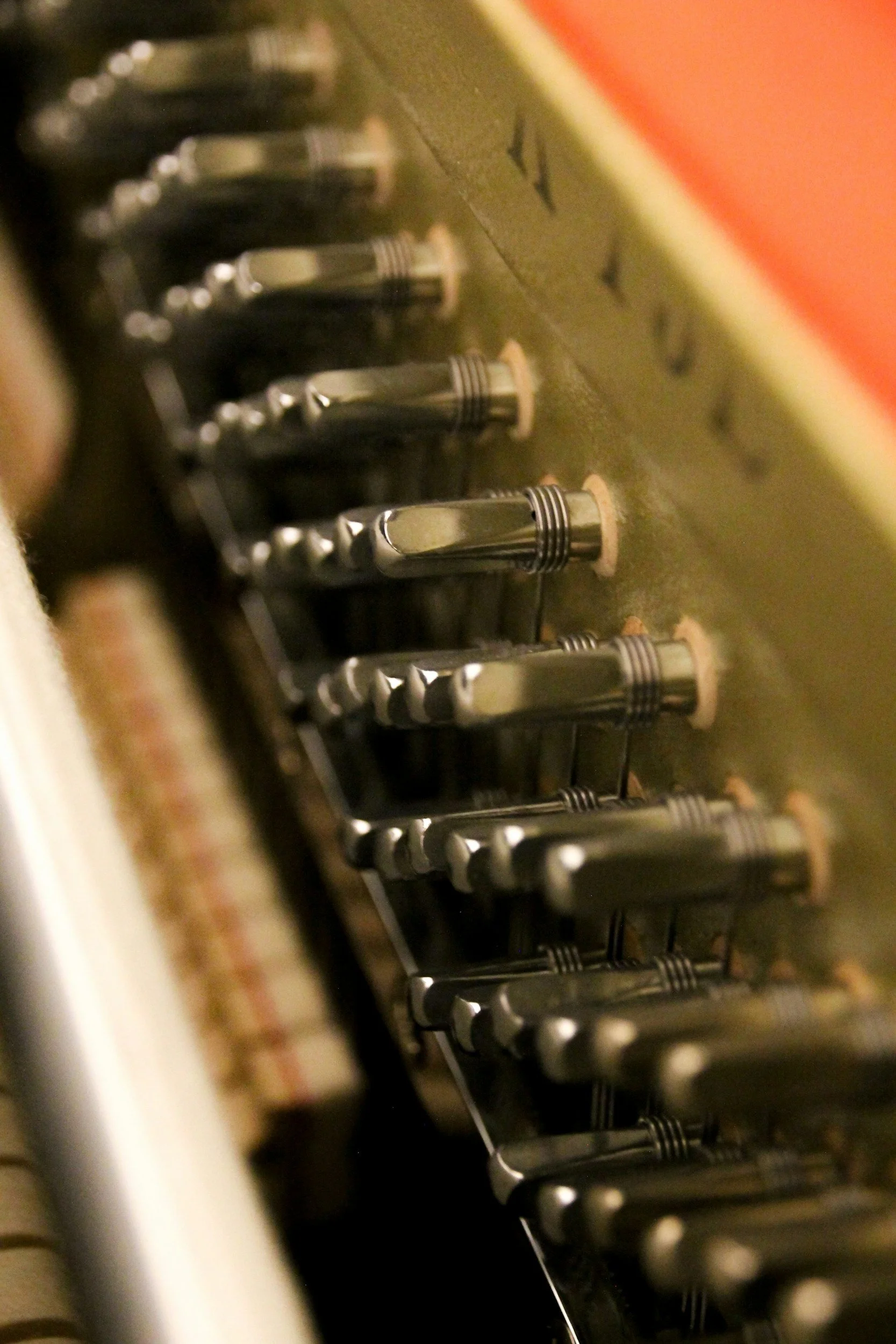Close-up of the inside of a vintage mechanical piano showing the metal hammers and strings.