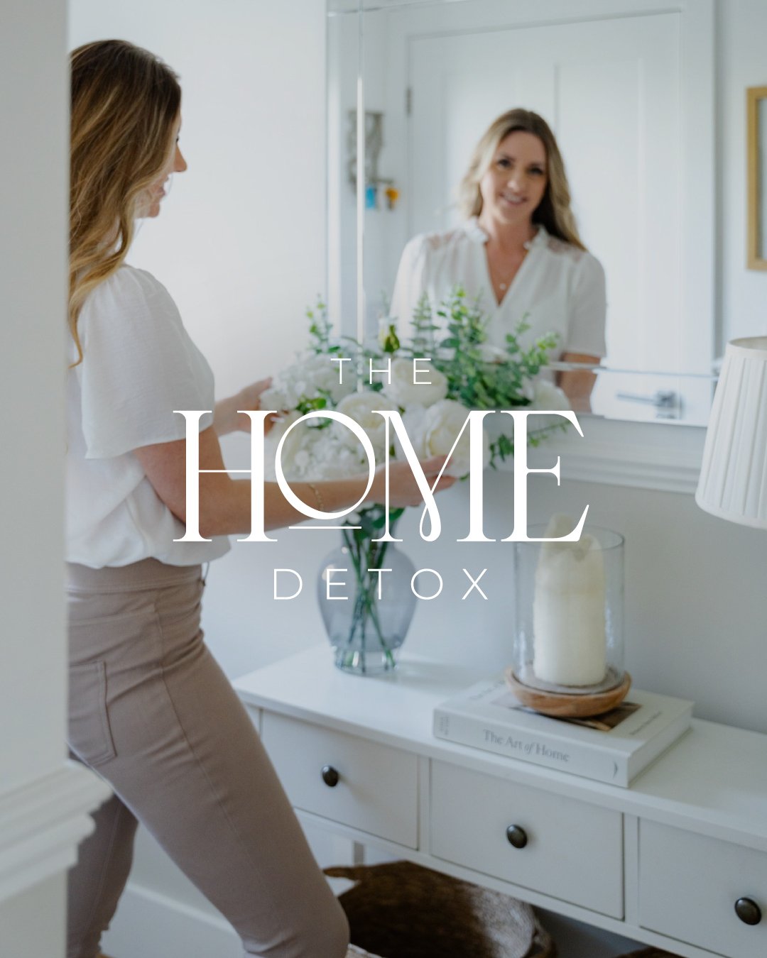 Woman holding a bouquet of white flowers in front of a mirror in a bright, modern home. Brand Identity for The Home Detox