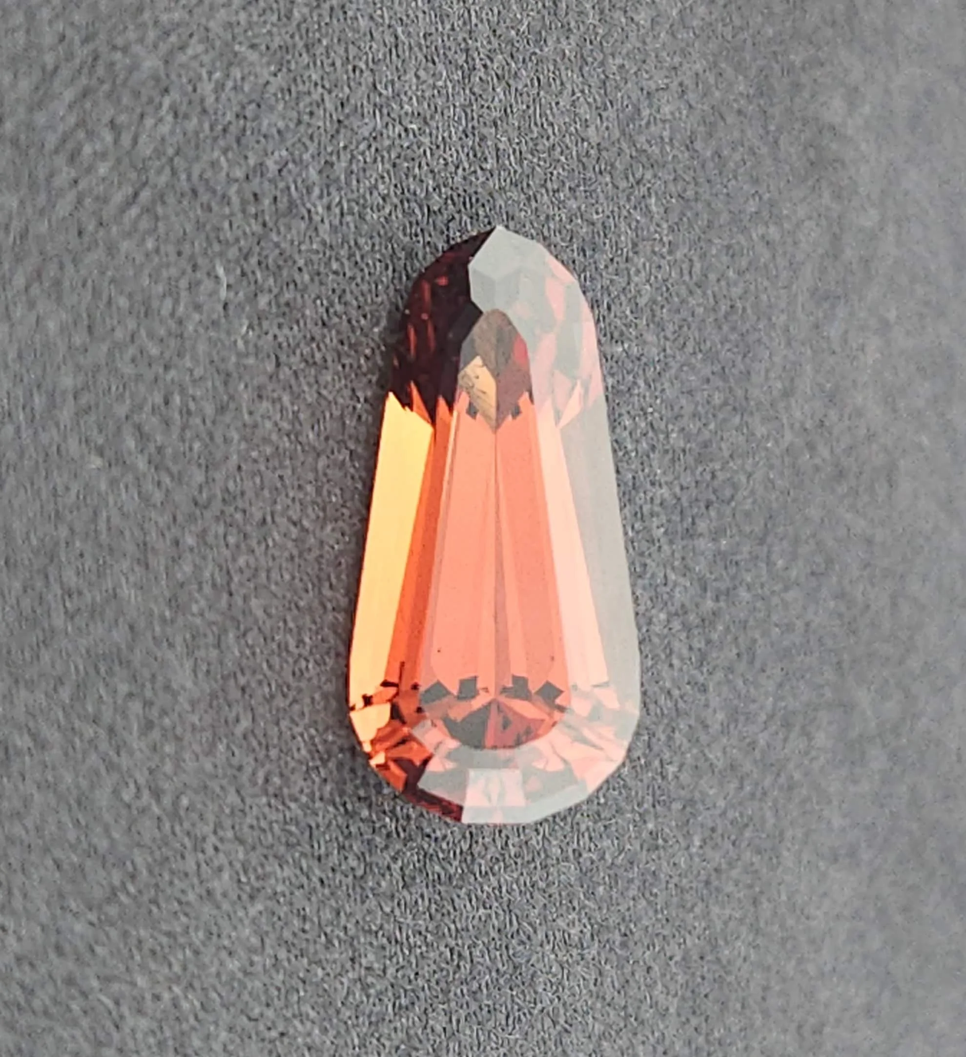 A paper craft of a fox on a gray carpeted floor, viewed from above.