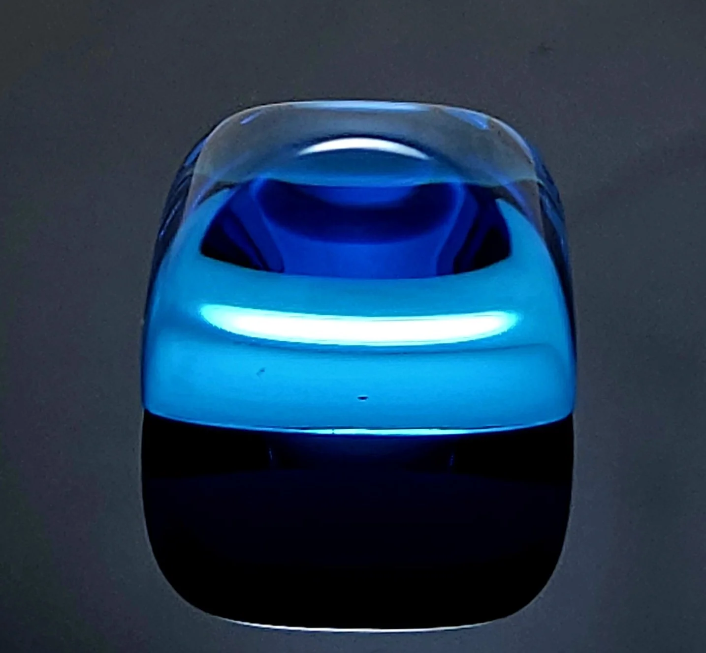 Hydrothermal blue quartz resting on a black reflective surface