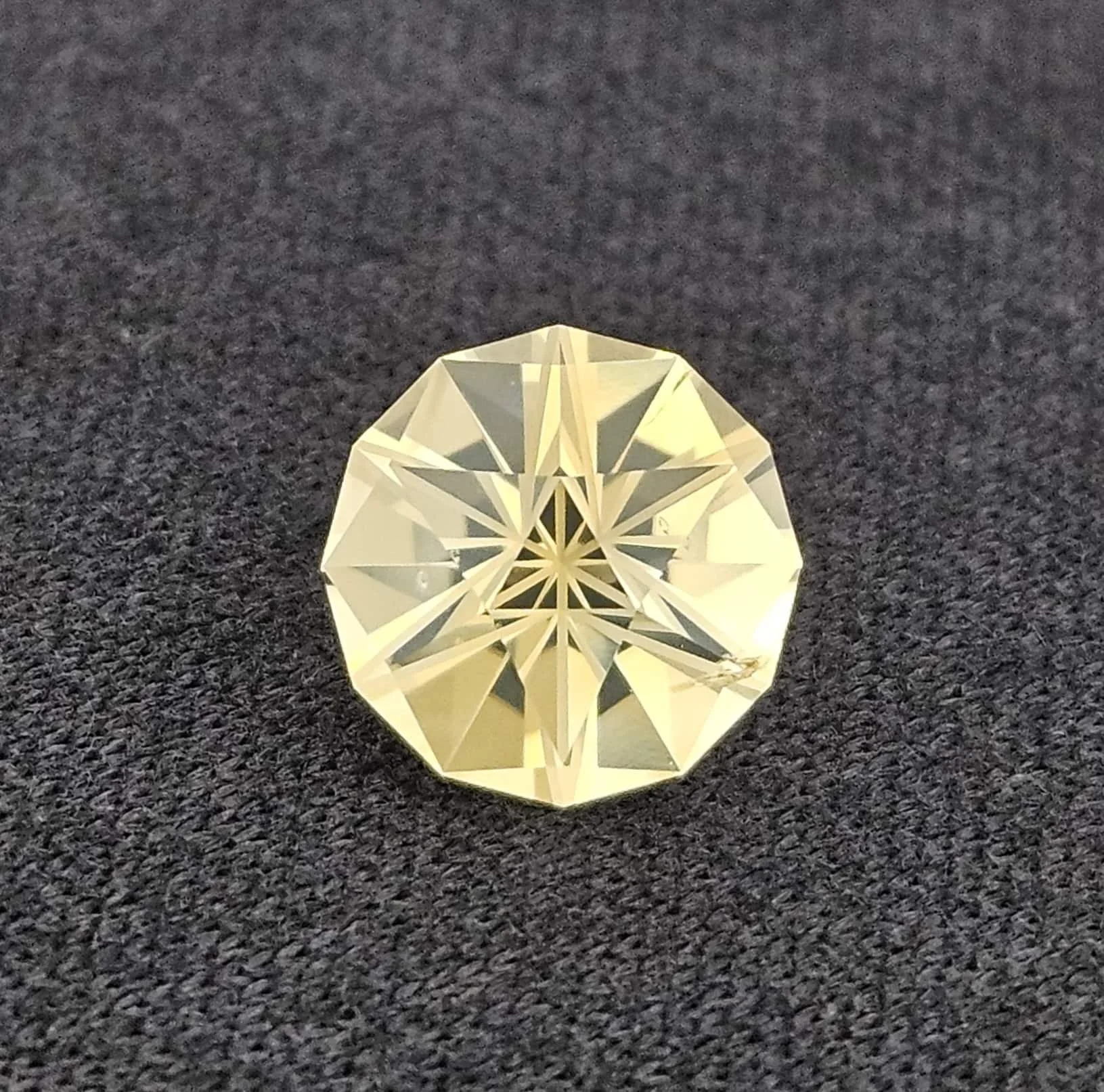 A clear, faceted crystal ball placed on a dark textured surface, with intricate geometric patterns reflecting inside.