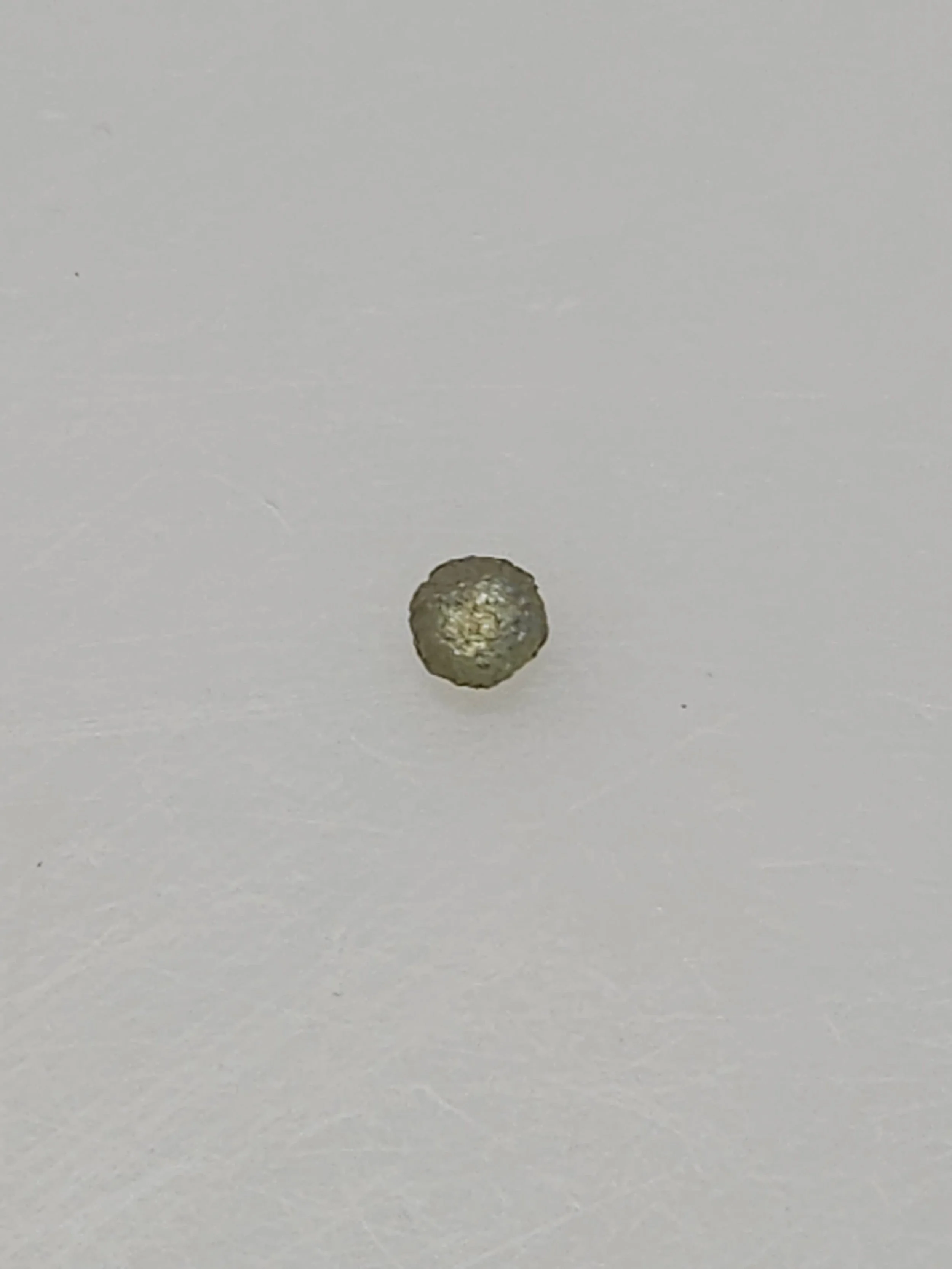 A rough Montana Sapphire resting on a white background.