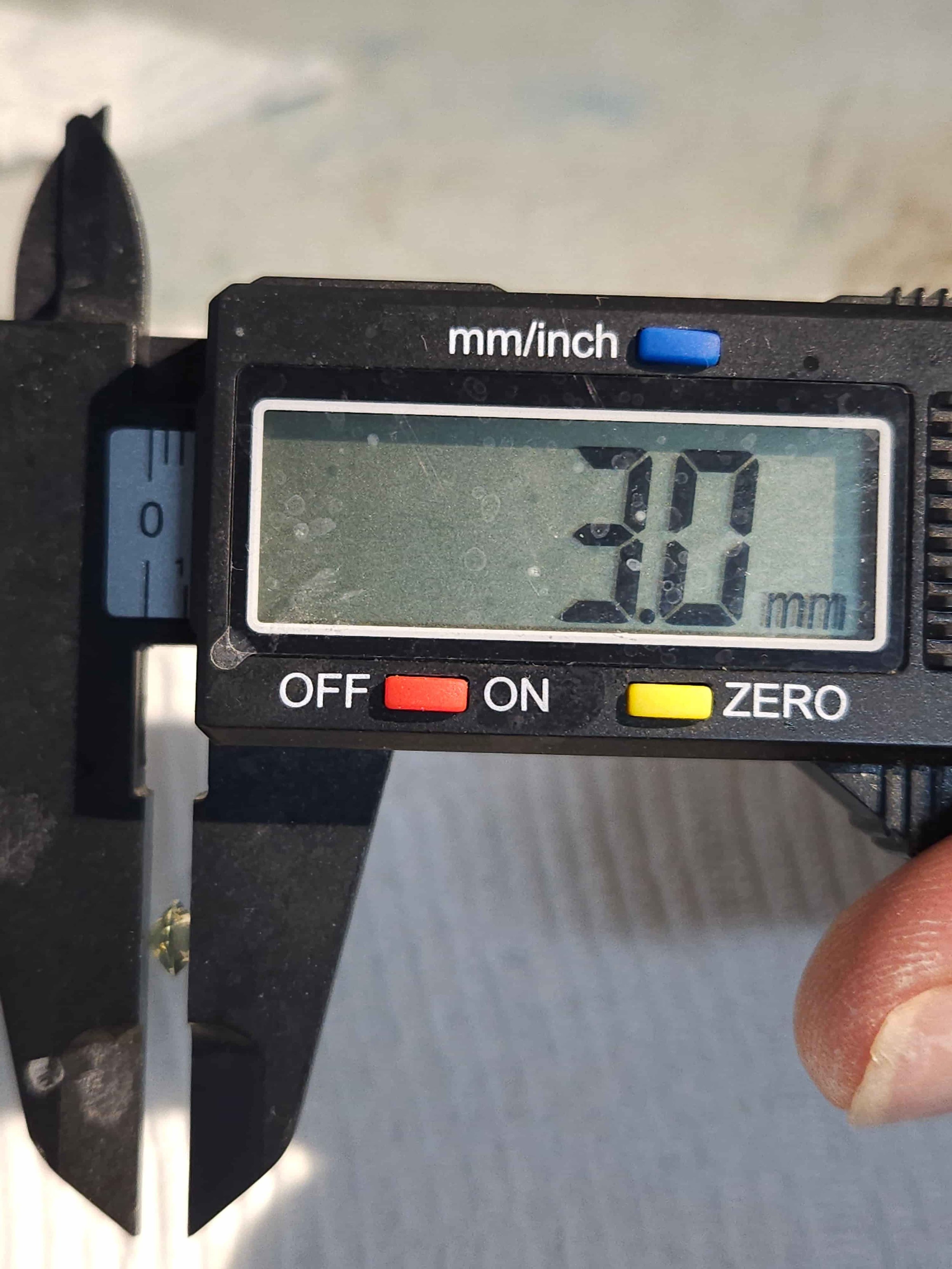A digital caliper measuring a sapphire.