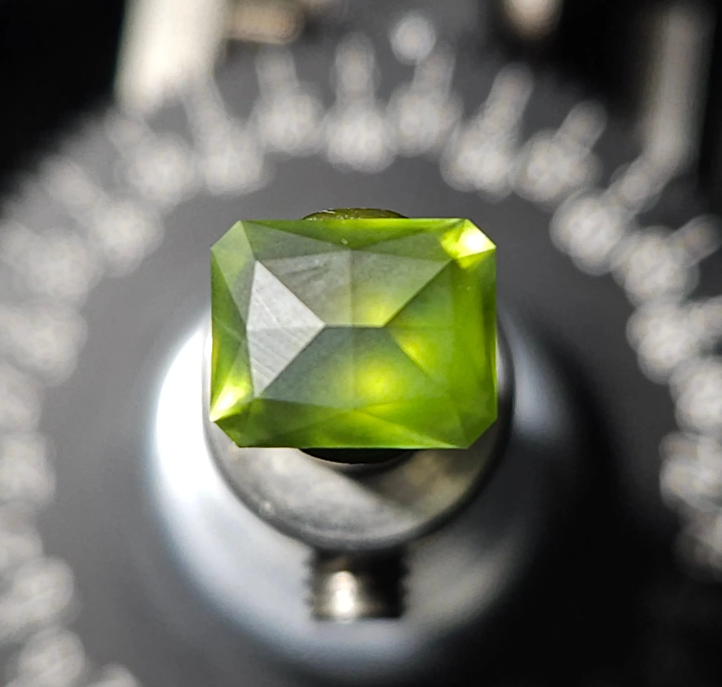 close up of a top down shot of the crown being cut at 500 grit with a blurred background of an index gear.