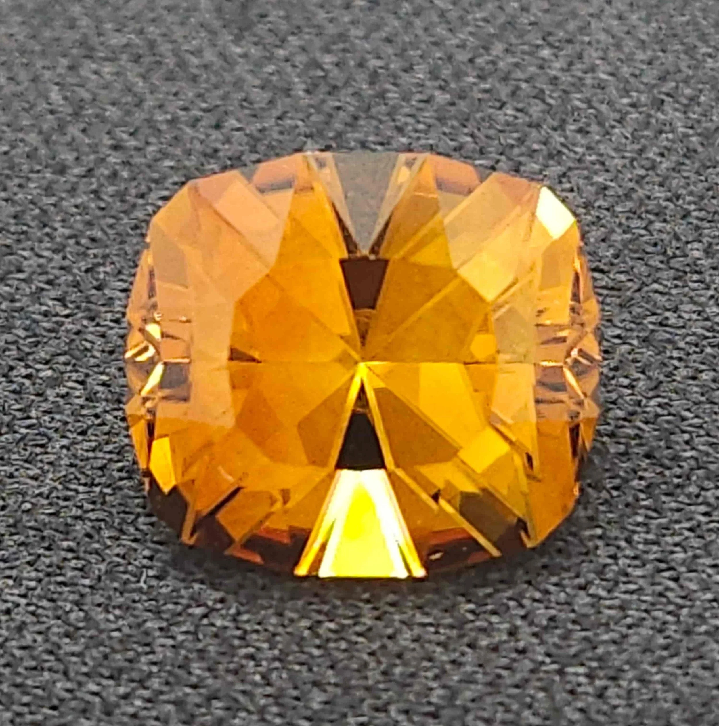 A glowing orange decorative pumpkin on a gravel surface.