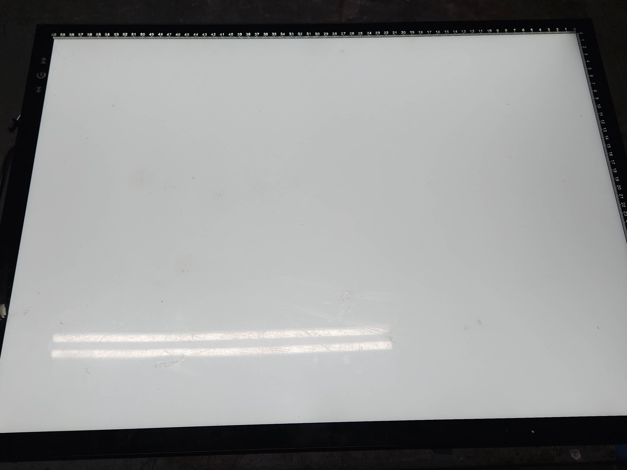 a white light table resting on a black surface.