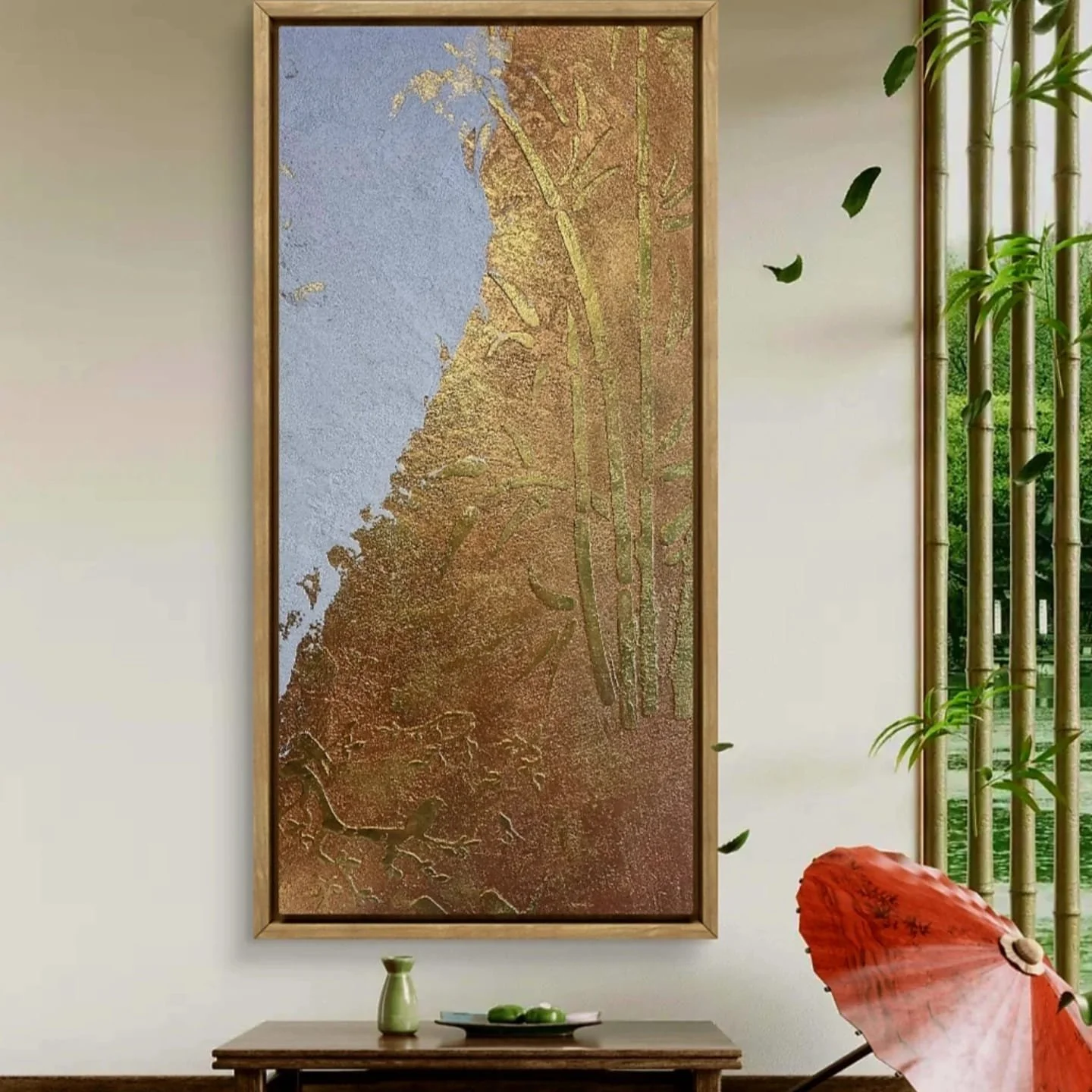 A framed artwork featuring abstract landscape with textured blue sky, greenery, and earthy tones, hung on a white wall in a room with bamboo accents and decorative items, including a red umbrella and green vase.