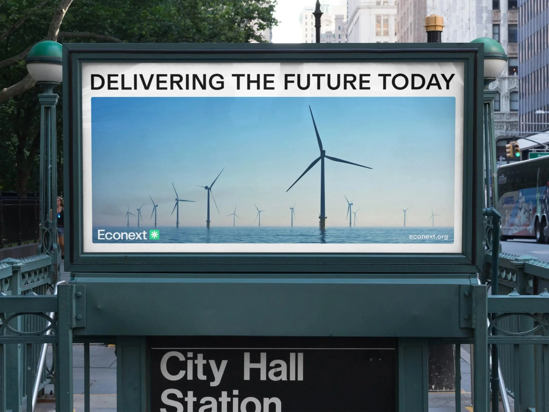 Billboard mit dem Slogan "Delivering the future today" und Windkraftanlagen im Wasser im Hintergrund, darunter das Logo von Econext.
