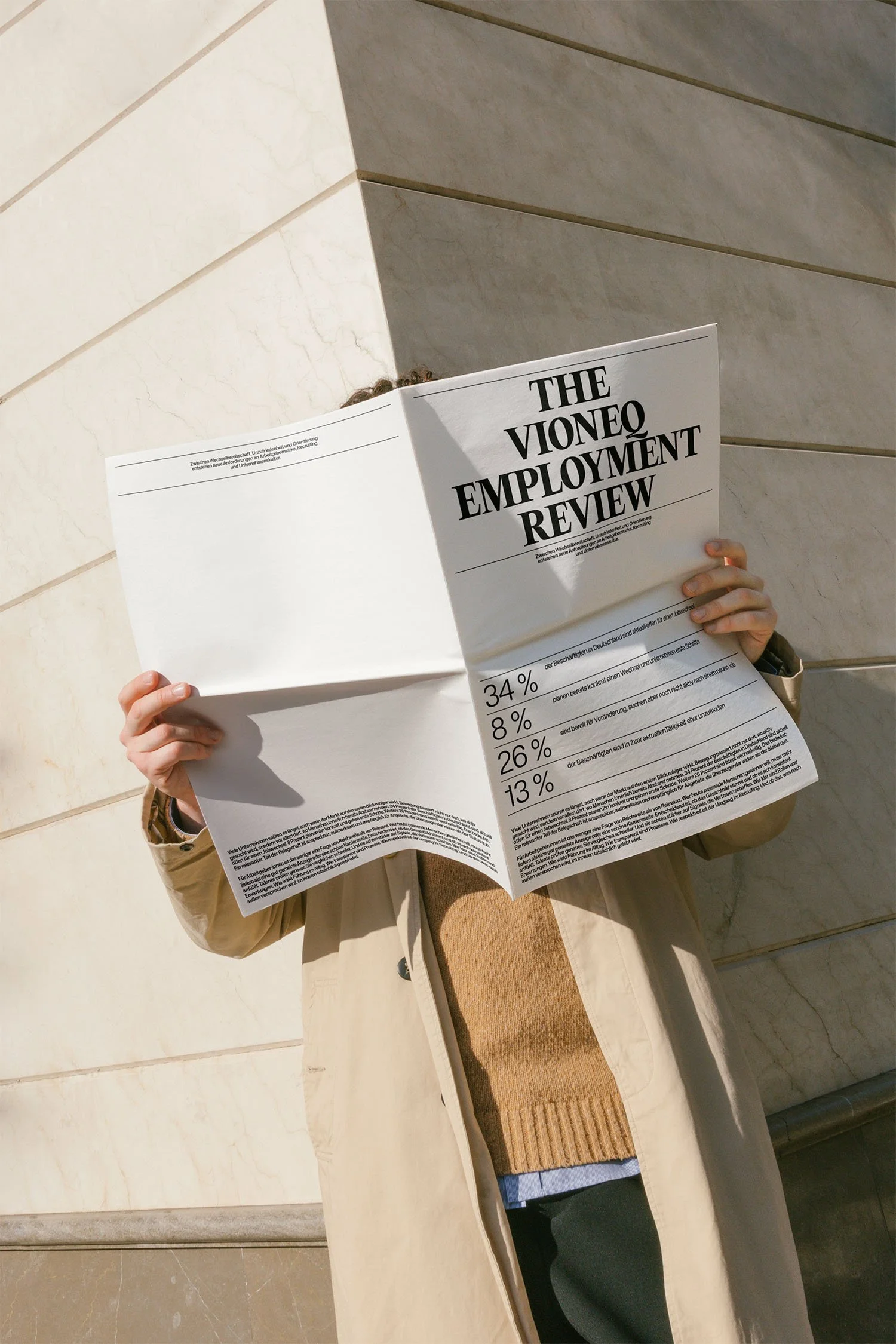 Eine Person liest einen Bericht mit dem Titel 'The VioneQ Employment Review'.