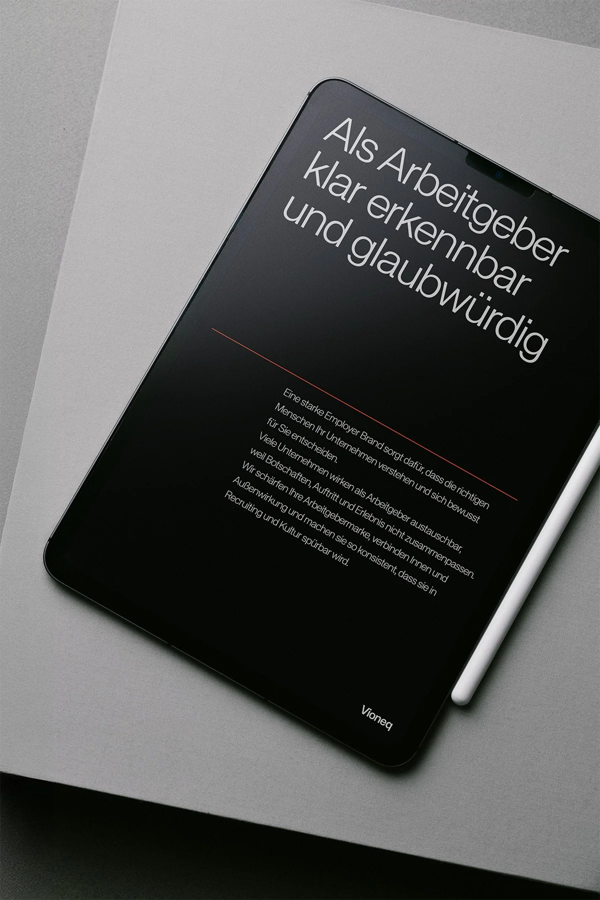 Ein Smartphone mit einem schwarzen Bildschirm und weißem Text auf einem grauen Hintergrund. Das Display zeigt die Überschrift: "Als Arbeitgeber klar erkennbar und glaubwürdig" und einen längeren Text darunter.