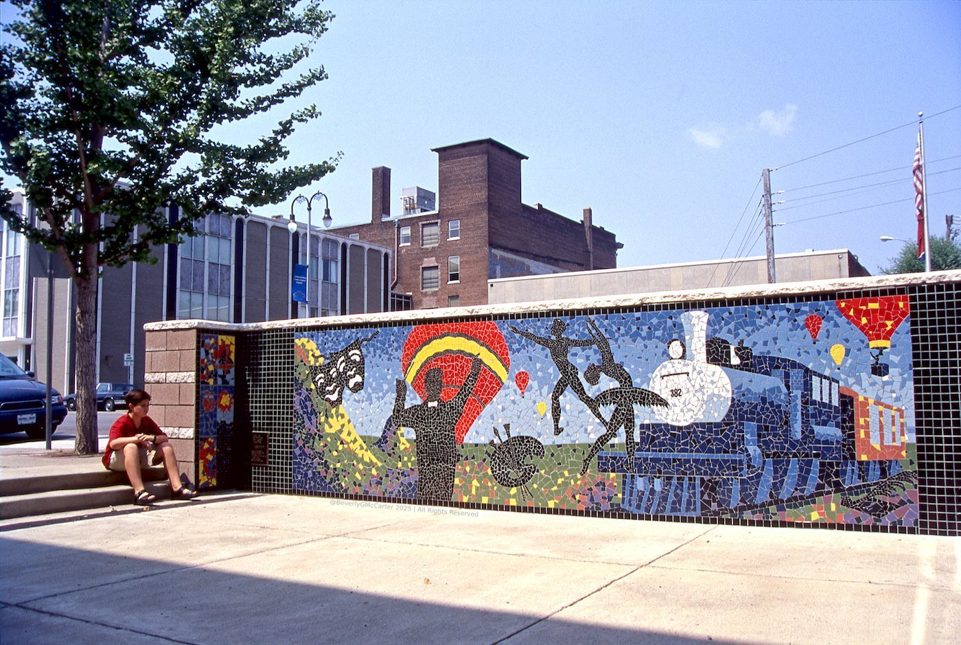 Jackson and the Arts mosaic mural by Beverly G. McCarter, depicting art groups over Jackson TN symbols like Pinson Mounds and train, 2000, 21x4 feet.