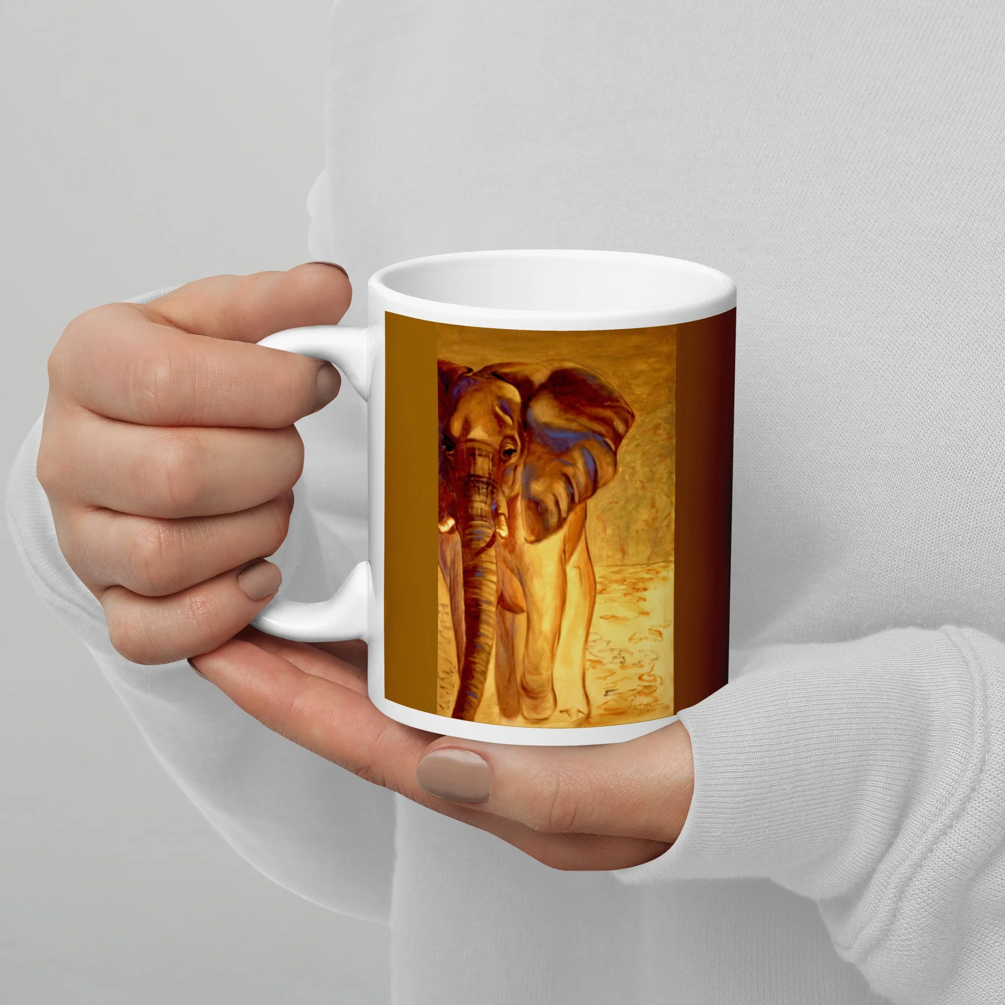 11 oz ceramic mug with Almost Gone oil wrap by Beverly G. McCarter, elephant in golden light on ochre background.