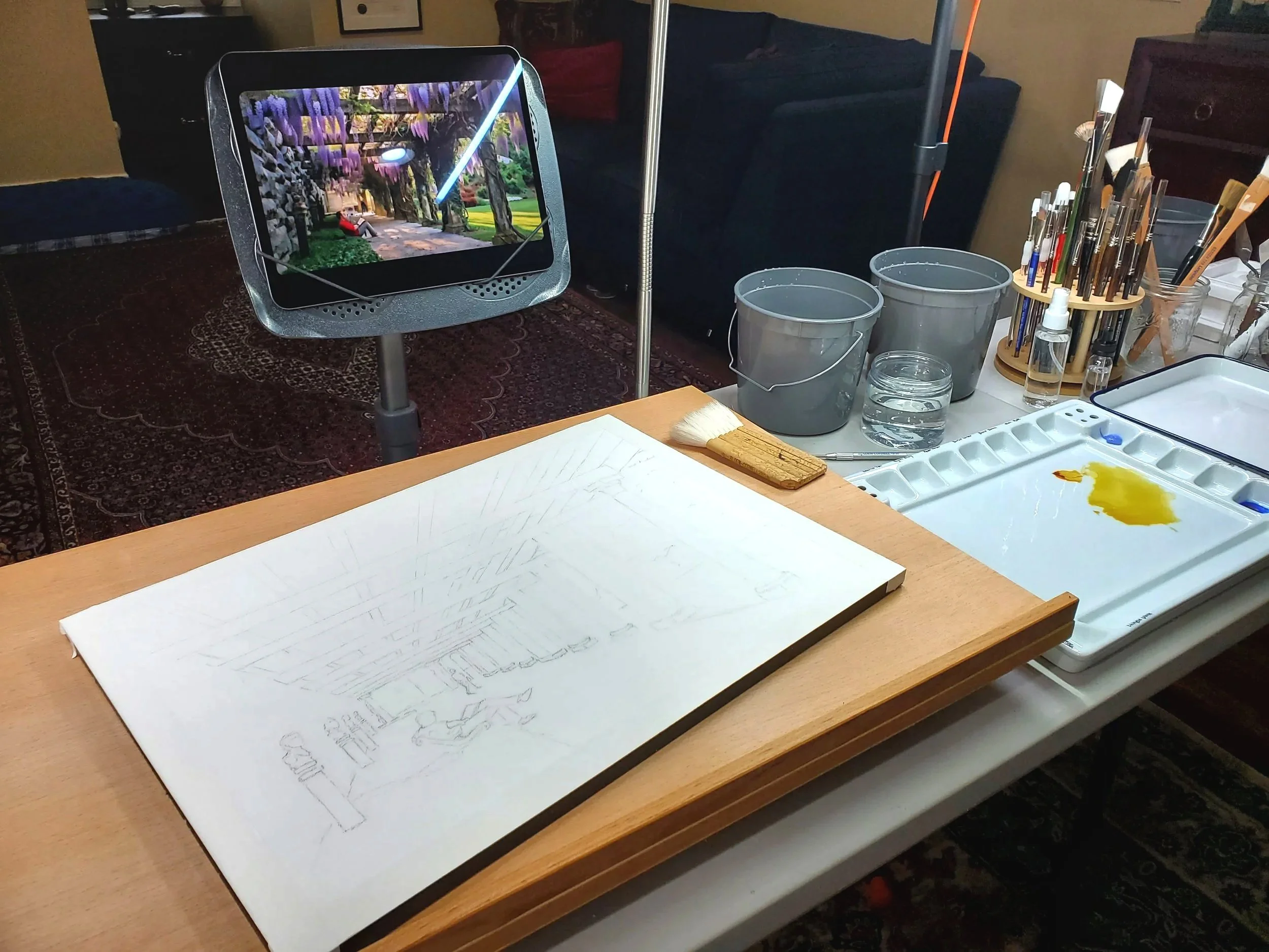 Image of the artist's painting easel in preparation for laying watercolor on a sketch.