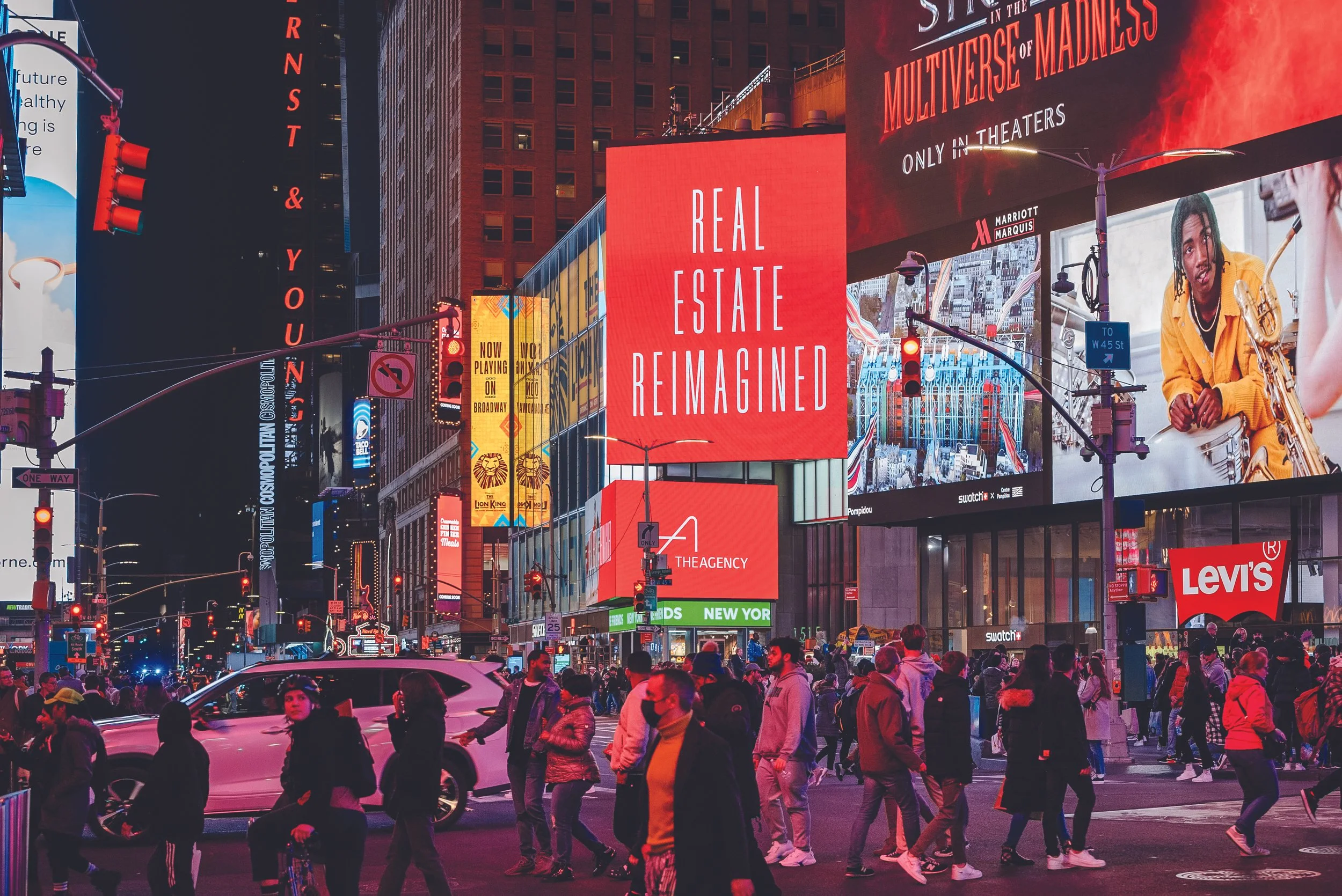 Nighttime scene of The Agency Real Estate billboard.