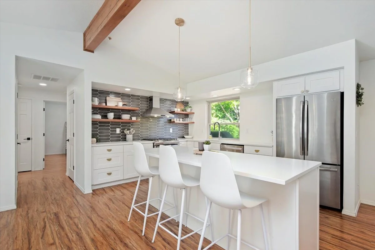 Modern open-concept kitchen with quartz countertops and stainless steel appliances in a Meridian, ID luxury home