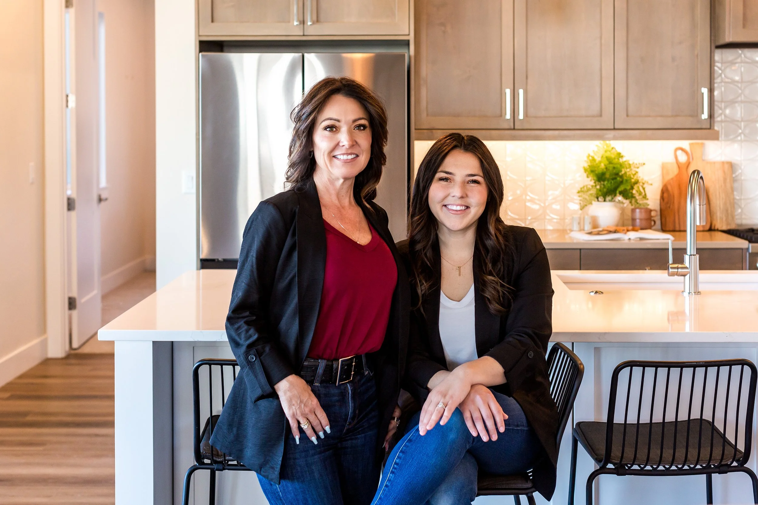 Boise Real Estate Agents, Jodi Harada and Dani Gonzales, smiling in the office.