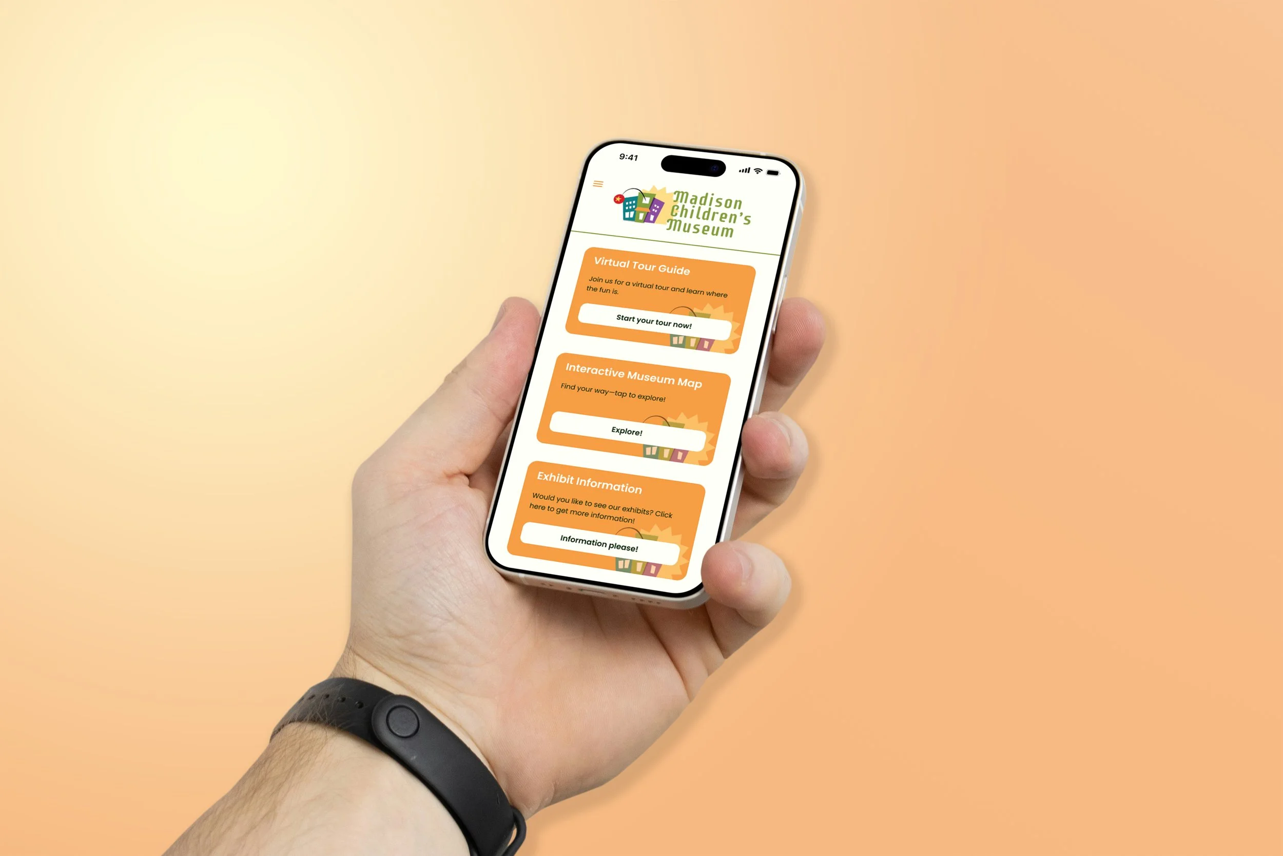 Hand holding a smartphone displaying the Madison Children's Museum website with options for a virtual tour, interactive map, and exhibit information.