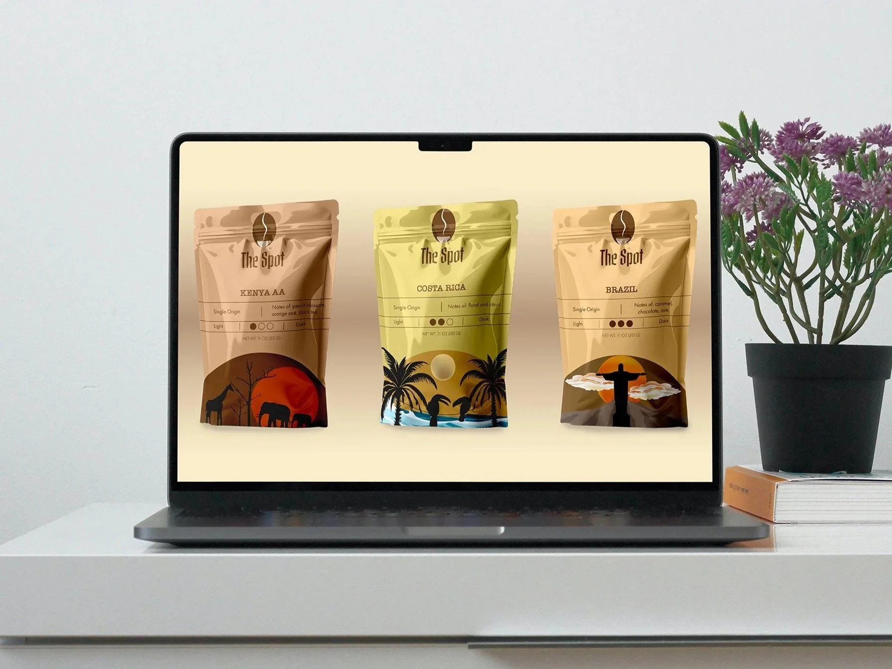 Laptop displaying three coffee bags labeled Kenya AA, Costa Rica, and Brazil, on a white surface with a potted plant and flowers beside it.