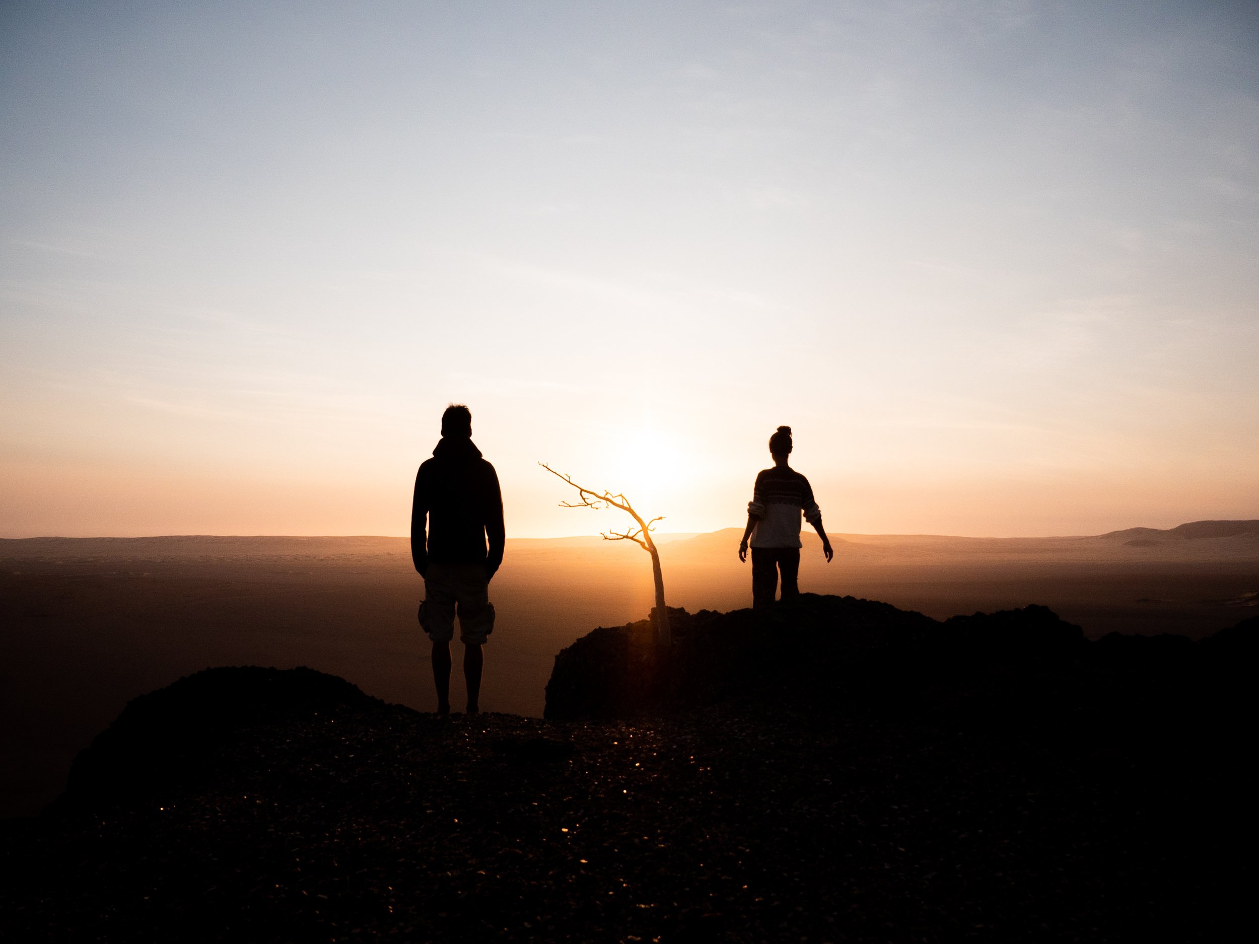 Nous deux, de dos, face à un coucher de soleil dans le désert du Namib en Namibie.