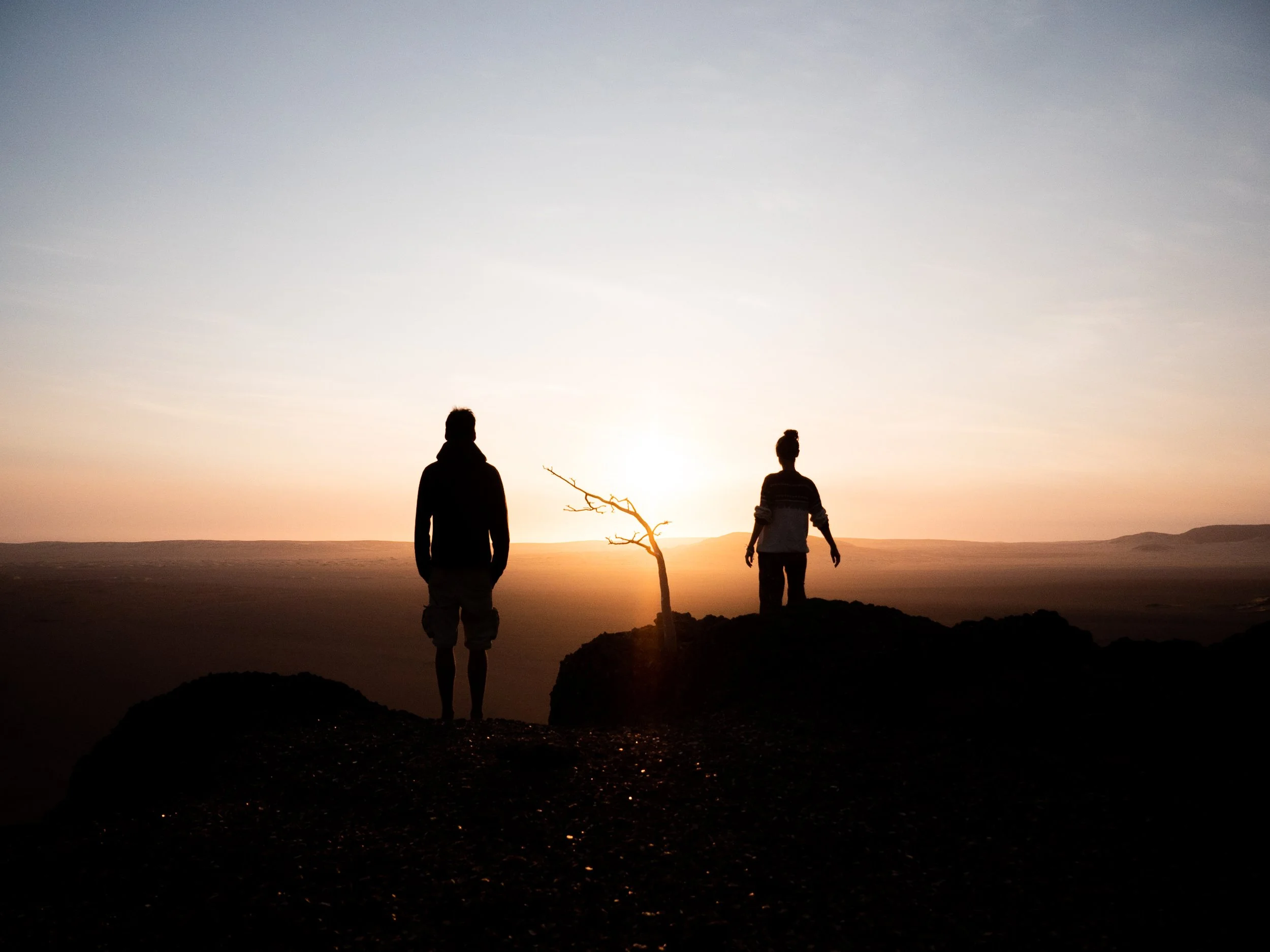 Nous sommes de dos, face à un coucher de soleil dans le désert du Namib en Namibie